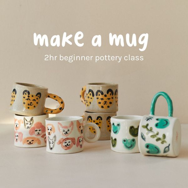 The image features a collection of handcrafted ceramic mugs. The mugs are decorated with various patterns: a cheetah print, dog faces, and frog-like designs. The mugs are stacked and arranged on a white surface against a light beige background. The ad text says "make a mug", followed by "2hr beginner pottery class".