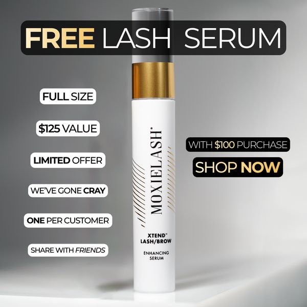 An advertisement featuring a white and gold lash serum bottle against a gradient gray background. Large text at the top reads "FREE LASH SERUM". Accompanying the bottle are callouts that say "FULL SIZE", "$125 VALUE", "LIMITED OFFER", "WE'VE GONE CRAY", "ONE PER CUSTOMER", and "SHARE WITH FRIENDS". Text towards the bottom of the bottle reads "XTEND LASH/BROW ENHANCING SERUM".  Smaller text next to SHOP NOW says "WITH $100 PURCHASE". The background is a smooth blend of light and dark grays.