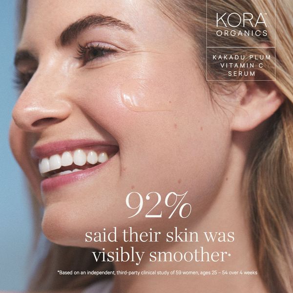 A close-up shot of a Caucasian woman smiling, showing the skin on the side of her face to highlight a skincare product. The woman has fair skin and appears to be in her late 30s or early 40s. Her skin appears smooth and glowing. A small amount of the product is visible on her face. The layout includes text that displays a claim about improved skin smoothness. The background is a soft gradient blue, focusing attention on the product and the woman's face.