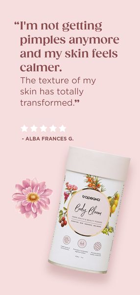 The ad features a light pink background. On the left side, there's an illustration of a pink flower. On the right side, a white cylindrical product container is displayed, labeled with the product name 'Body Bloom.' Below the container, there is a testimonial quote from Alba Frances G. about the effectiveness of the product. The overall layout is clean, with the text and product presented in a visually appealing manner.