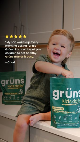 The ad features a happy, smiling young child holding a package of a nutritional supplement in hands. The child is positioned in front of a counter looking straight toward the camera.  Text above the child's head includes a five-star rating and a testimonial about the product and its ease of use. Two packages of the product are visible, one held by the child and another on the counter. The background is a kitchen setting.