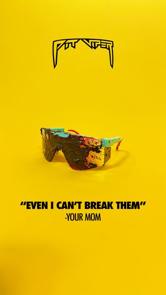 The ad features a pair of uniquely designed sunglasses against a bright yellow background. The sunglasses, which appear to be stylized, have a colorful, textured effect on the lenses and frames. Above the sunglasses, a logo is featured. Below the sunglasses, the text "EVEN I CAN'T BREAK THEM" is displayed, followed by "-YOUR MOM". The overall composition is clean and straightforward, drawing attention to the product and its implied durability.
