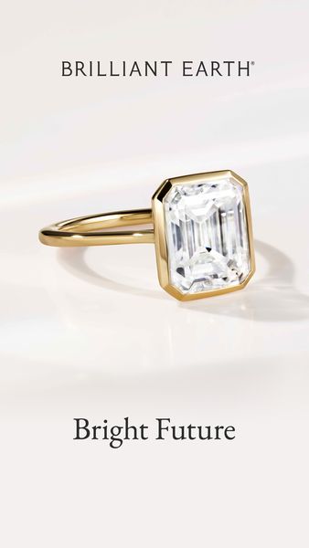A vertical ad displays a gold ring with a large, rectangular, emerald-cut diamond set against a soft, white background. The ring is positioned slightly off-center, with its sparkling diamond prominently featured. The setting of the diamond is within a gold bezel and is in sharp focus, while the rest of the scene is softly lit. Below the ring, against the white backdrop, the words "Bright Future" are placed. The overall aesthetic is elegant and minimalist, emphasizing the engagement ring's beauty and the theme of a promising future.