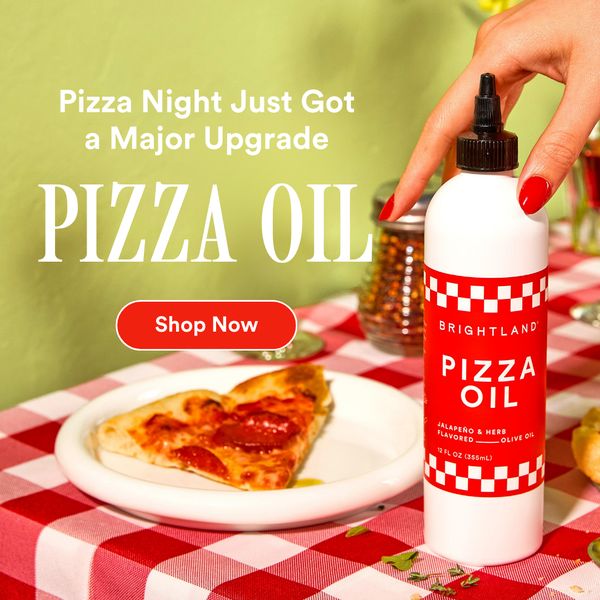 The ad showcases a bottle of pizza oil set against a backdrop of a red and white checkered tablecloth. A slice of pizza sits on a white plate in the foreground. The bottle is white with a red label featuring a checkered design and has the name 'PIZZA OIL' prominently displayed. Text above reads 'Pizza Night Just Got a Major Upgrade' and 'Shop Now' is displayed inside a red button. A hand with red nail polish is holding the bottle. The overall composition presents a visually appealing and appetizing scene.