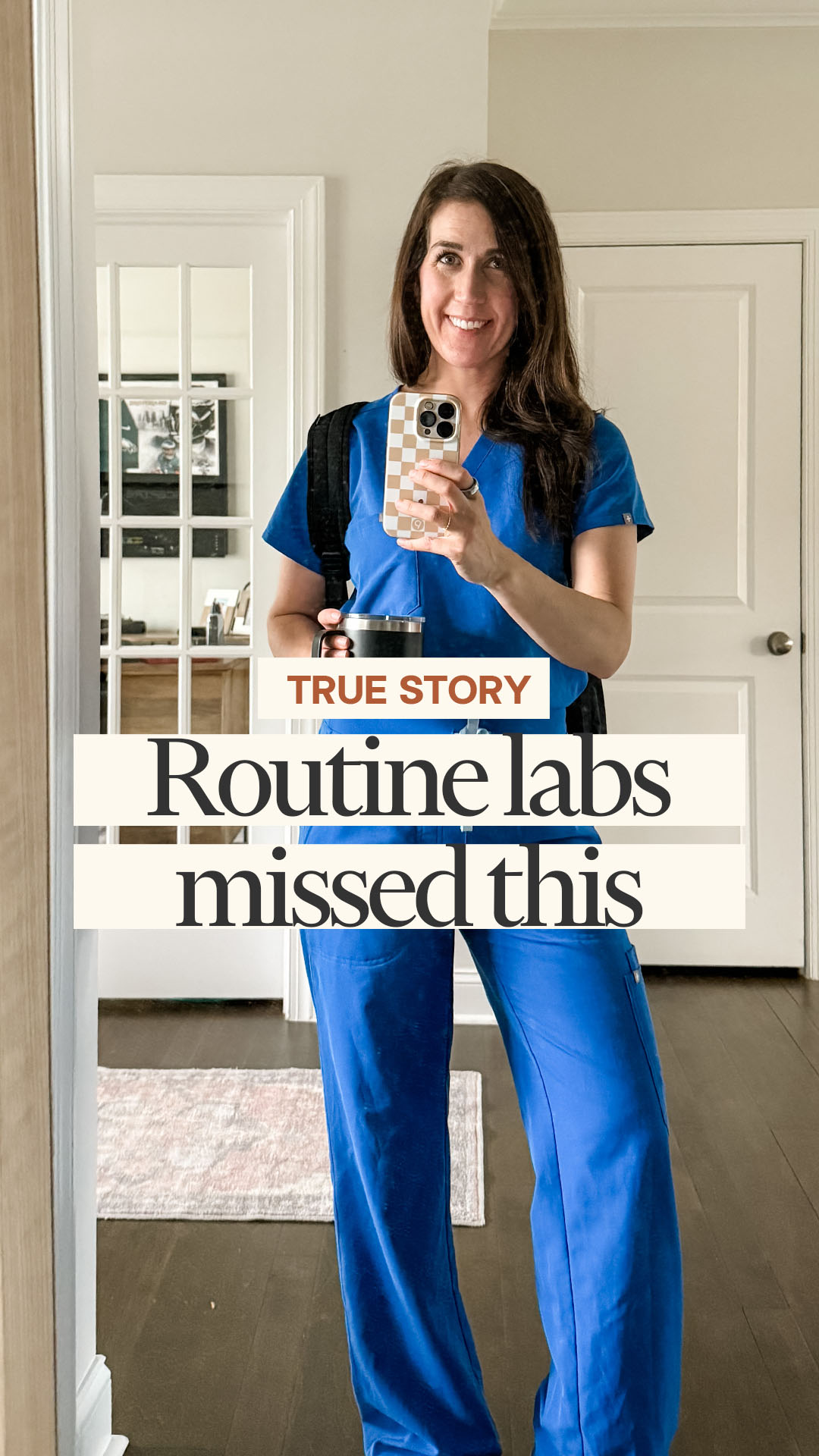 A woman in blue scrubs smiles at the camera while taking a selfie in a mirror. She is holding a phone in her right hand and a travel mug in her left. Text overlays on the image read "TRUE STORY" and "Routine labs missed this." The woman appears to be a healthcare professional, possibly on her way to or from work. The background shows a home interior with doors and a rug.