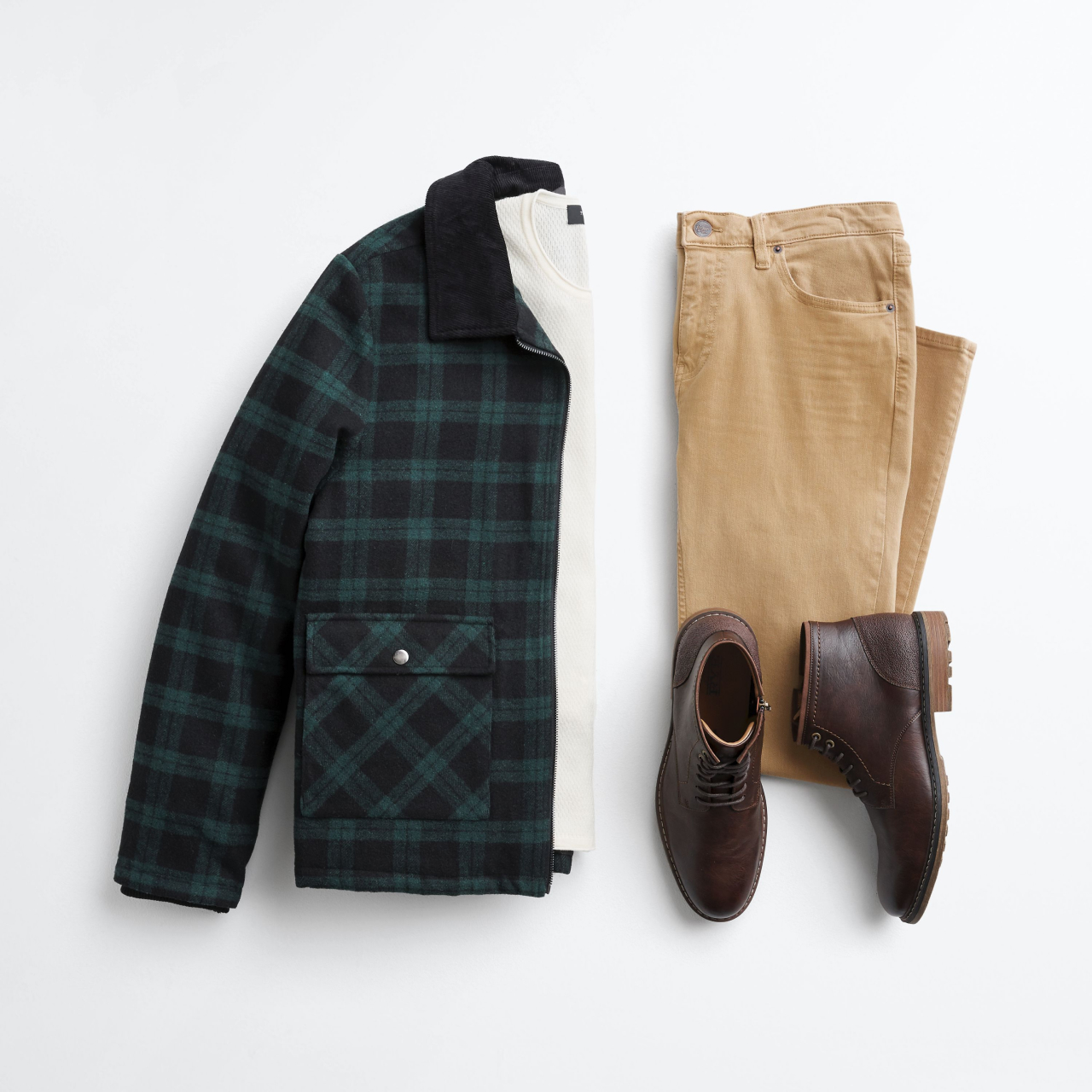 A flat lay of men's clothing is displayed against a white background. The outfit includes a green and black plaid jacket, a cream-colored long-sleeved shirt, tan pants, and brown lace-up boots. The text overlay explains the Stitch Fix service, inviting users to take a quiz to receive personalized clothing selections that match their style, build, and budget, with the option to try items at home without hassle.