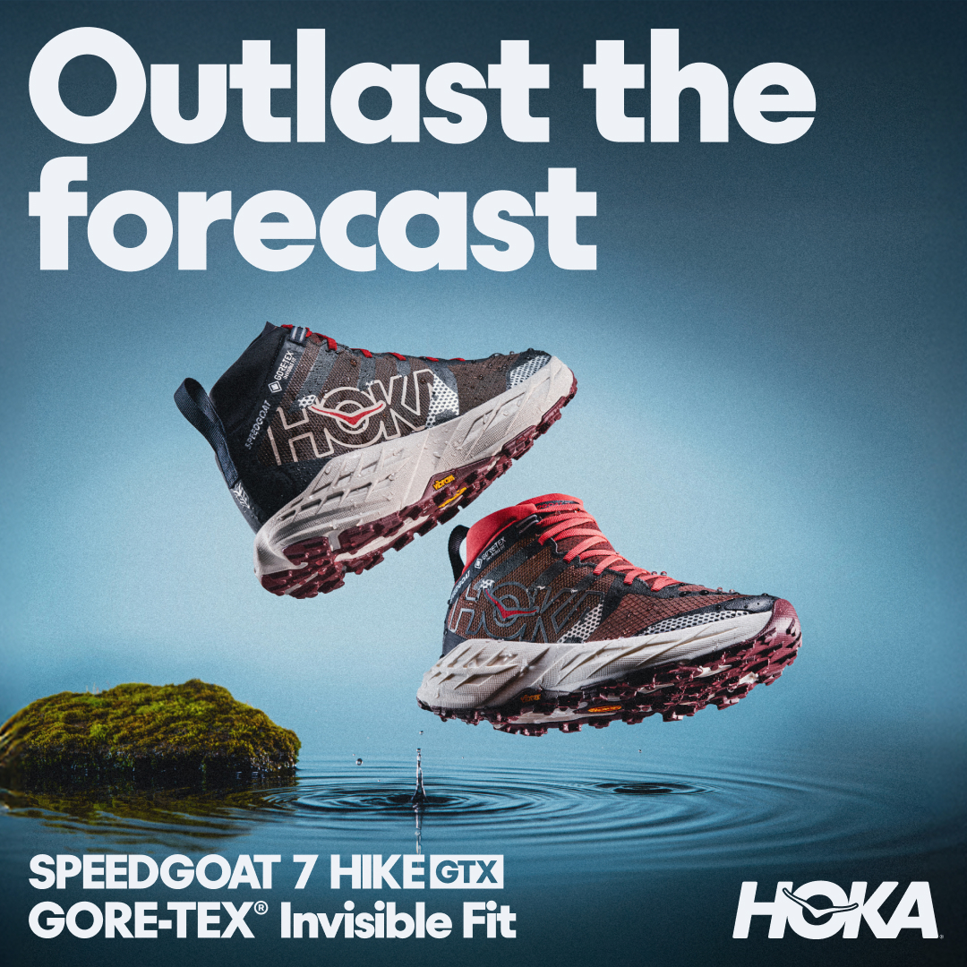 Two Hoka Speedgoat 7 Hike GTX shoes are shown suspended in the air above rippling water. A small mossy rock sits to the left of the shoes. Large white text at the top of the image reads "Outlast the forecast". Below the shoes, white text identifies the product as "SPEEDGOAT 7 HIKE GTX GORE-TEX® Invisible Fit". The Hoka logo is visible in the bottom right corner.