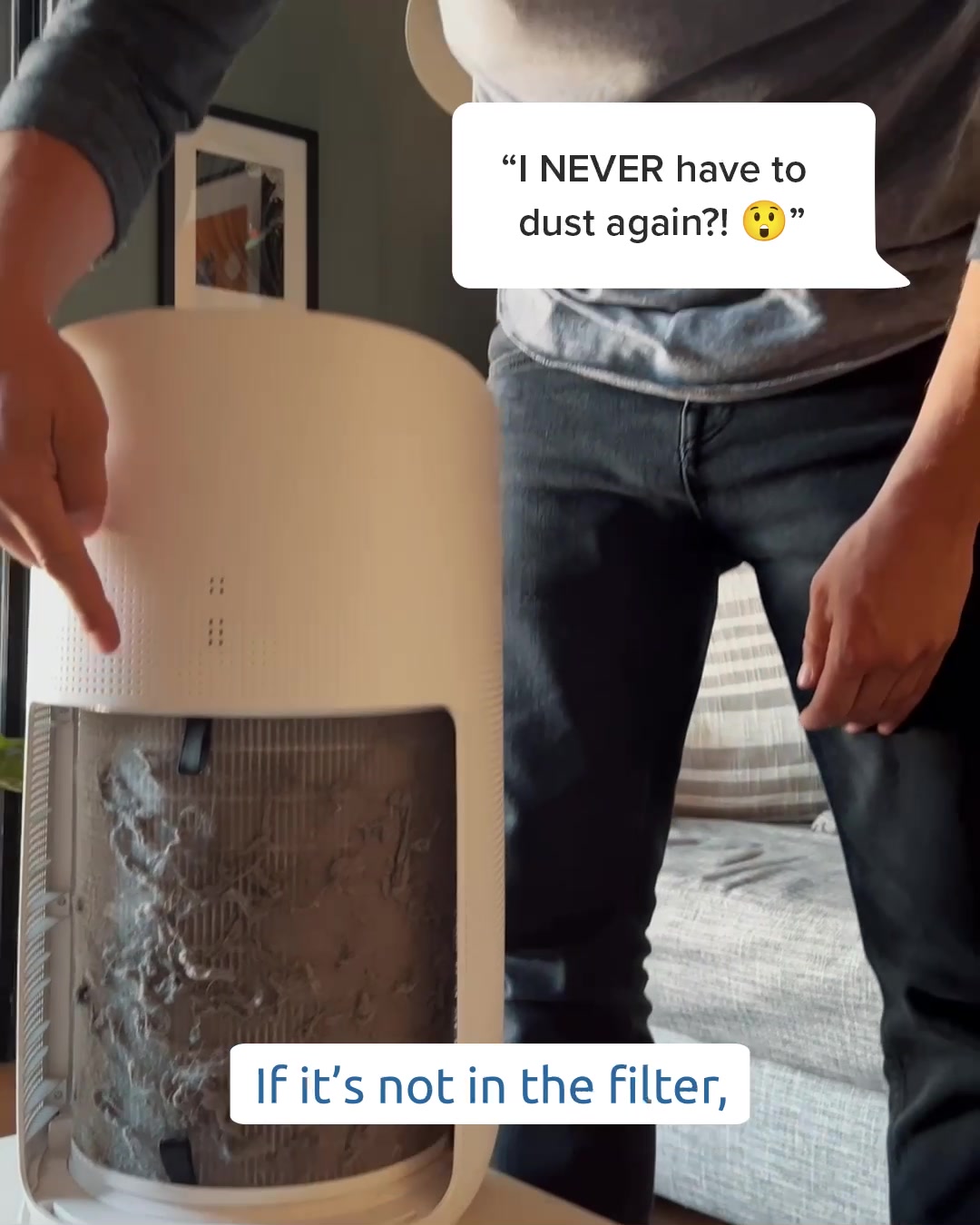 A person points to the dirty filter of a white air purifier. A speech bubble above the person's head asks, "I NEVER have to dust again?! 😳". Below the air purifier, text reads, "If it's not in the filter,". The image implies that the air purifier captures all dust, eliminating the need for manual dusting.