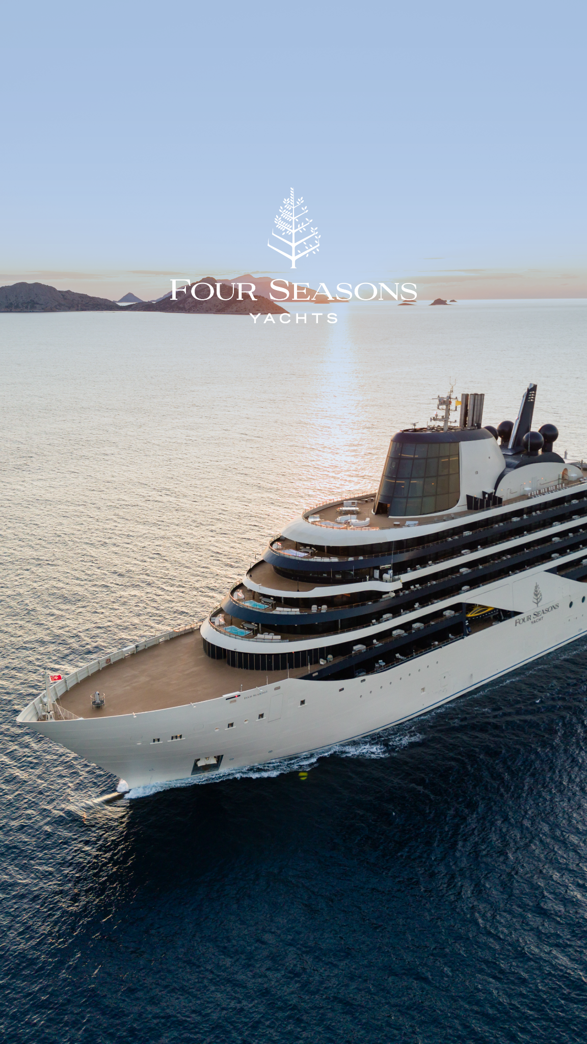 An aerial shot shows the front of a large, modern cruise ship sailing on calm, blue water during sunset. The sun reflects off the water, creating a shimmering effect. The ship has multiple decks with balconies and a distinctive glass-enclosed observation area at the top. The words "FOUR SEASONS YACHTS" are displayed in white text over the image, with a stylized tree logo above them. The copy "A holiday season shaped by the sea. Sail between turquoise coastlines and intimate islands aboard Four Seasons I." is also present.