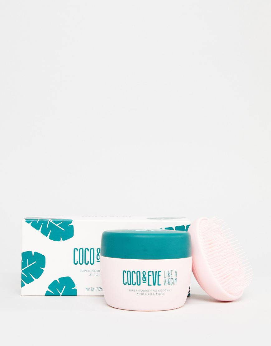 A product shot of a pink jar of Coco & Eve hair masque with a teal lid sits next to its white box packaging, which features teal palm leaves. A pink hairbrush is placed to the right of the jar. The jar has text that reads "COCO & EVE LIKE A VIRGIN SUPER NOURISHING COCONUT & FIG HAIR MASQUE". The box has text that reads "COCO & SUPER NOURISH & FIG Net Wt. 212m".
