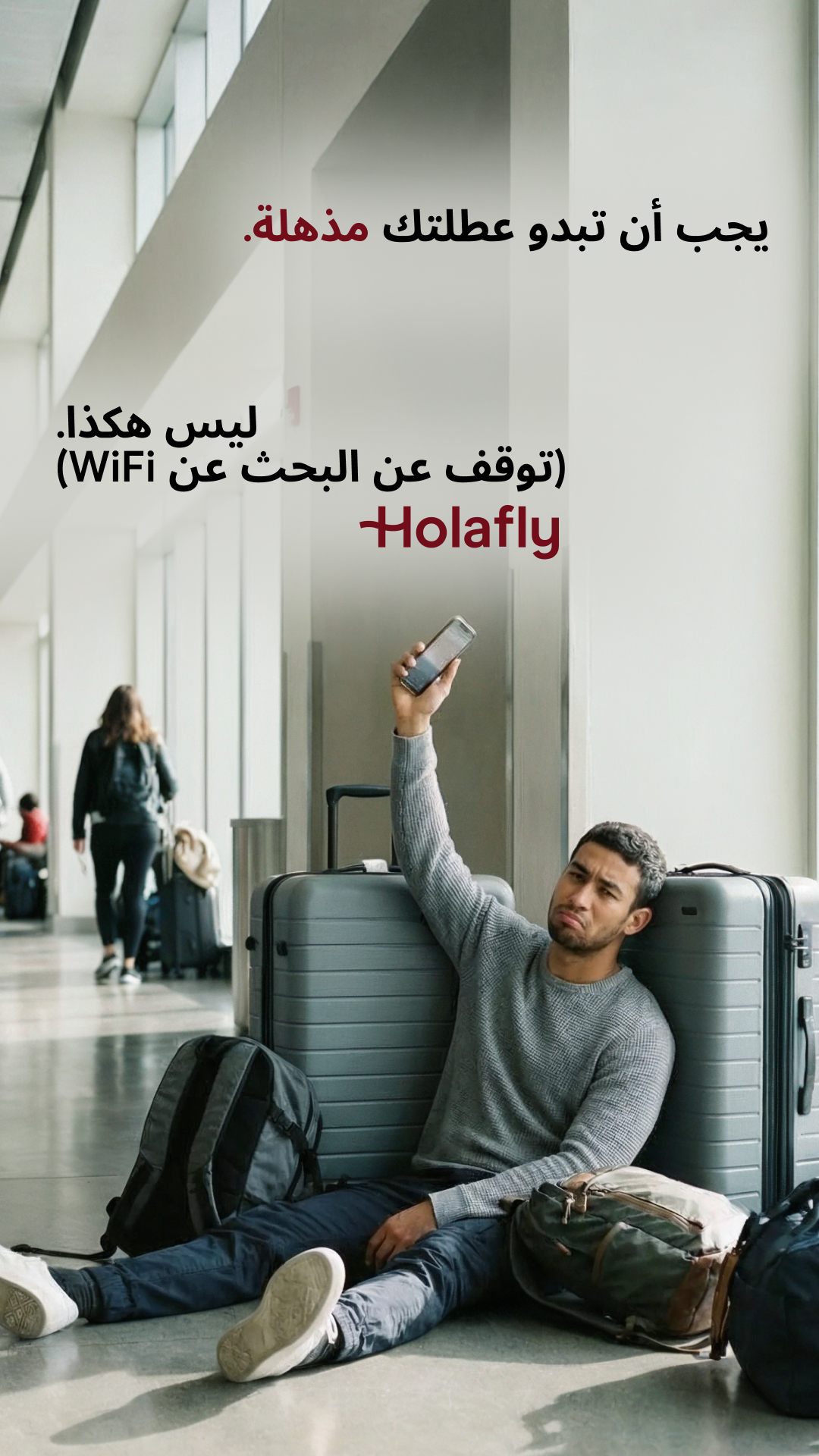 A man is sitting on the floor in an airport terminal, leaning against a suitcase, looking frustrated and holding up his phone as if trying to get a signal. Text overlays in Arabic read "Your vacation should look amazing." and "Stop searching for WiFi (Holafly)". The image depicts the common travel frustration of being unable to connect to the internet, positioning Holafly as the solution. The overall scene conveys a sense of travel inconvenience and the desire for seamless connectivity.