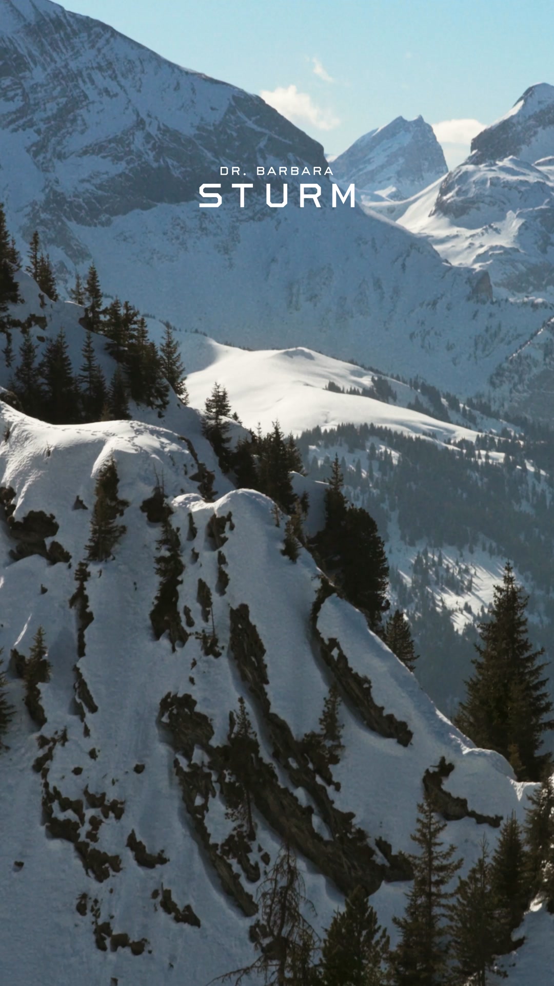 The image shows a majestic snow-covered mountain range under a clear blue sky. The text "DR. BARBARA STURM" is overlaid in large, white, sans-serif capital letters across the middle of the frame. Below this, in smaller white text, it reads "Gift A Moment with Dr. Barbara Sturm." The overall impression is one of luxury and natural beauty, evoking a sense of aspiration and high-end skincare.