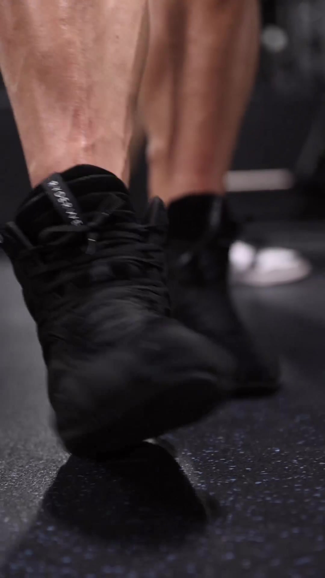 The creative shows a close-up of a person's legs and feet wearing black weightlifting shoes. The shoes are the main focus, with the legs blurred in the background. Text overlays the image, asking "Are you looking to elevate your weightlifting performance?" and "Experience the difference with Ryderwear's D-Mak Bodybuilding Shoes."
