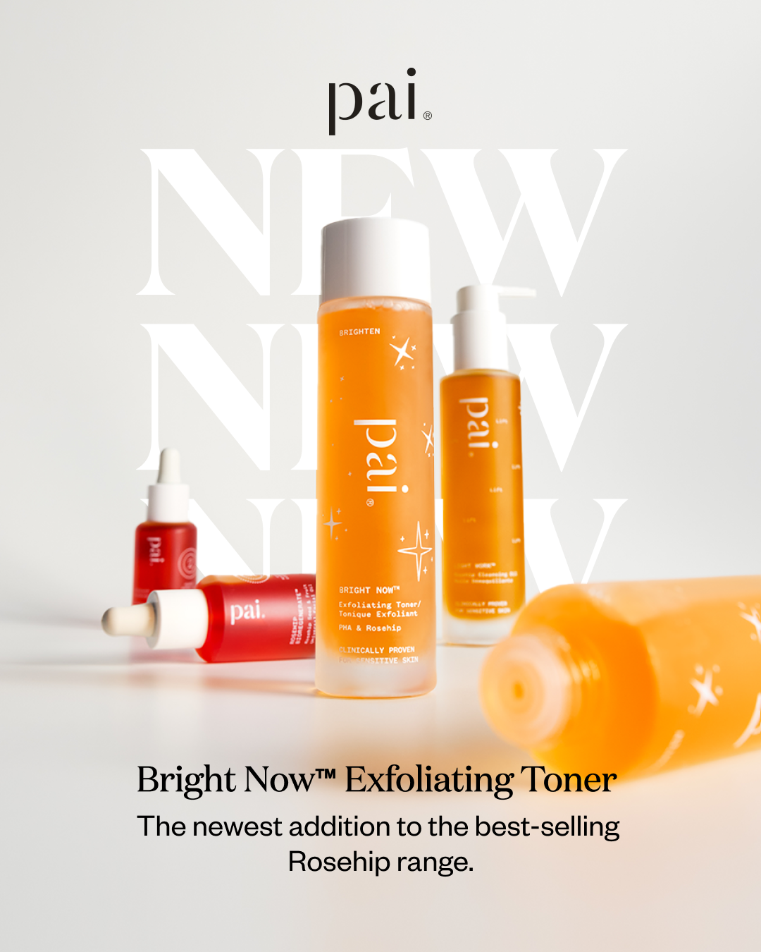 The image showcases the Pai Skincare "Bright Now™ Exfoliating Toner" with a clean, minimalist aesthetic. Several bottles of the toner, in various sizes and one with a dropper, are arranged on a white surface against a light grey background. The brand's logo "pai." is prominently displayed at the top. Large, faded "NEW" text is overlaid behind the product bottles. Below the product arrangement, the headline "Bright Now™ Exfoliating Toner" is presented, followed by the descriptive text "The newest addition to the best-selling Rosehip range."