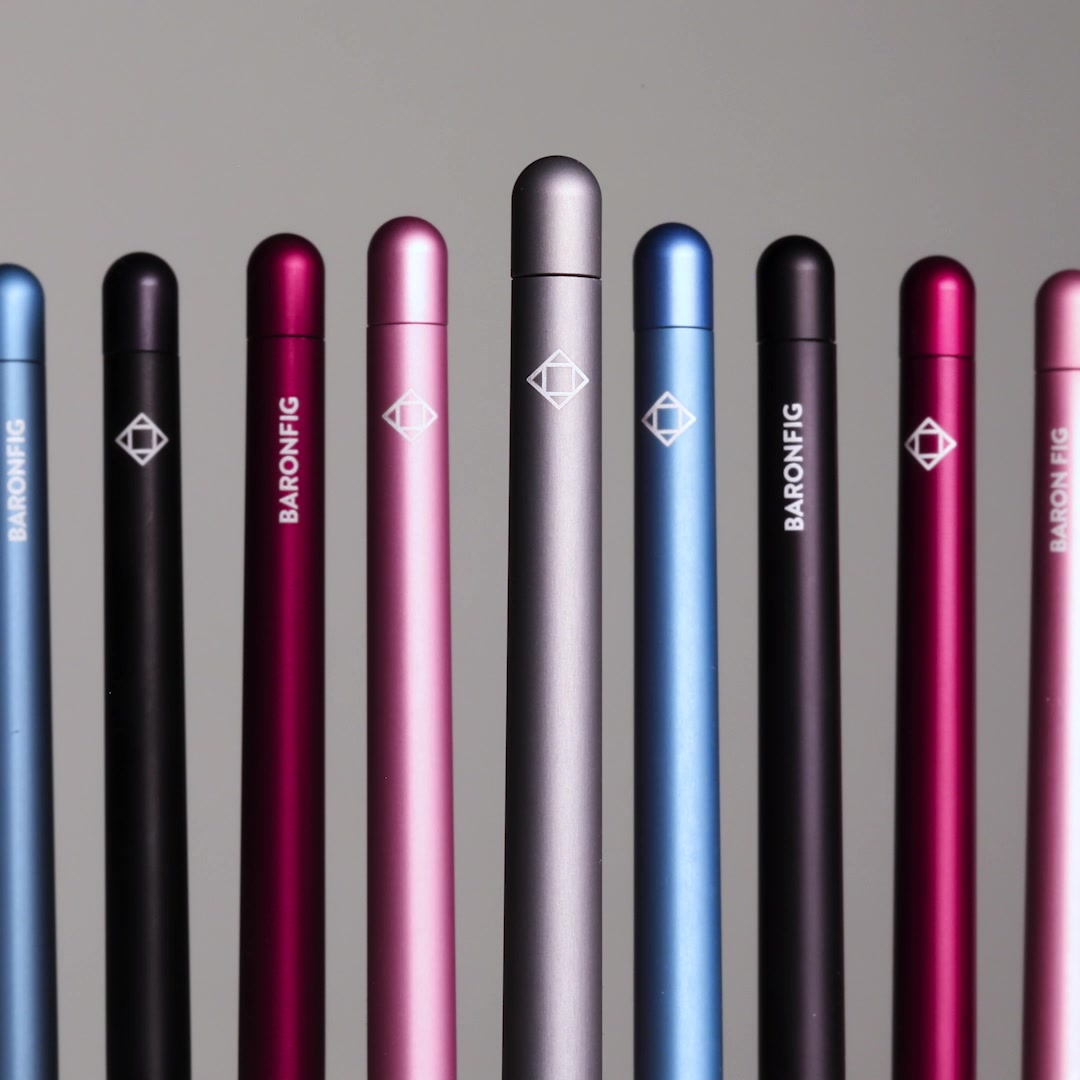 A straight-on, eye-level shot shows a row of nine Baronfig pens against a neutral grey background. The pens are arranged in a slightly staggered formation, with the tallest pen in the center. Each pen is a different color, including light blue, black, dark pink, light pink, grey, and a brighter blue. The Baronfig logo, a diamond shape with intersecting lines, is visible on most of the pens. White text overlays the image, stating "Get in front of people—and stay there—by putting your brand on the #1 rated pen in the world." Below this, smaller text reads "Be remembered with Baronfig. Made in USA. 💡"