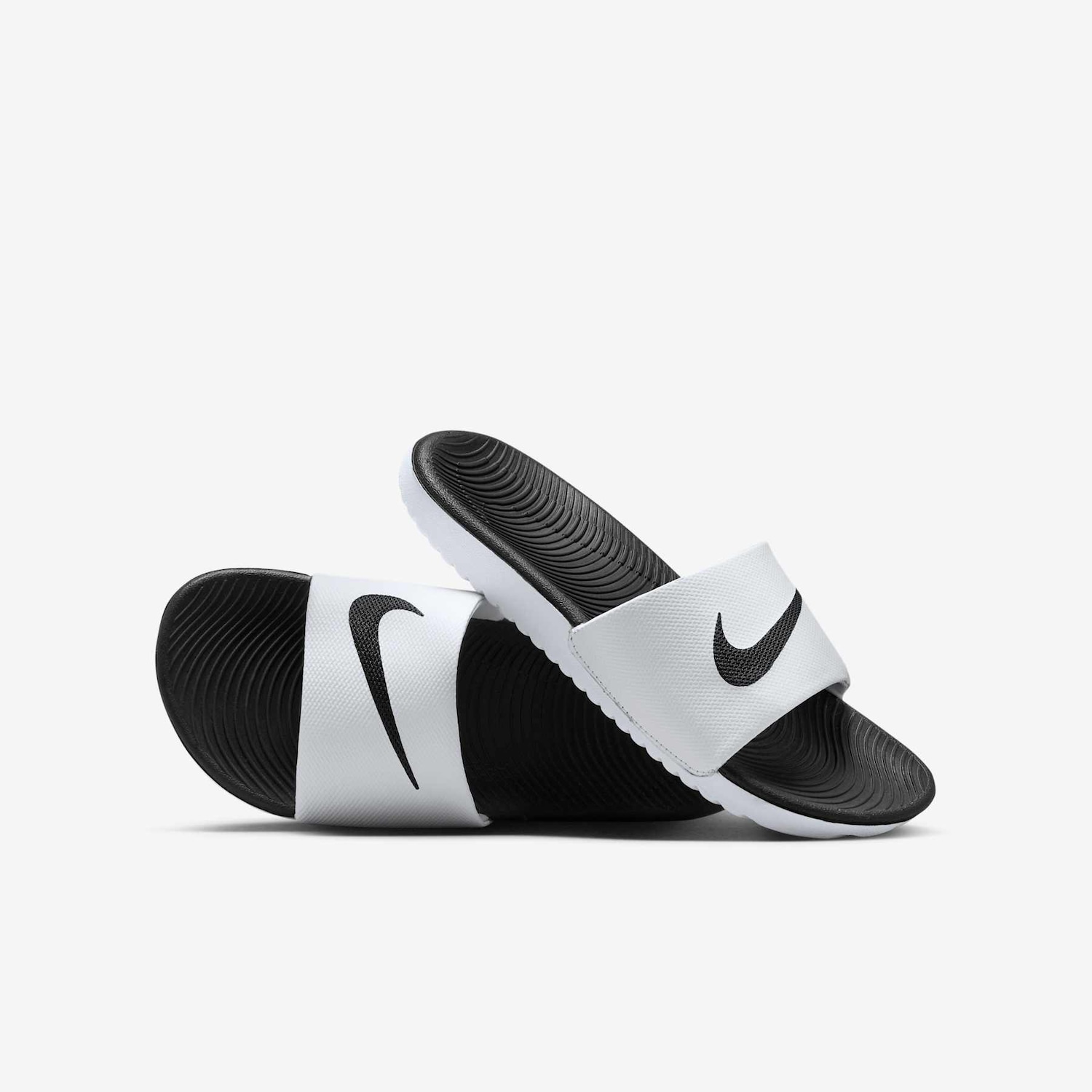 A pair of black and white Nike slide sandals are displayed against a plain light grey background. The sandals are positioned with one slightly overlapping the other, showcasing their design. The image is a clean product shot, with no additional text or graphics overlaid on the visual itself.