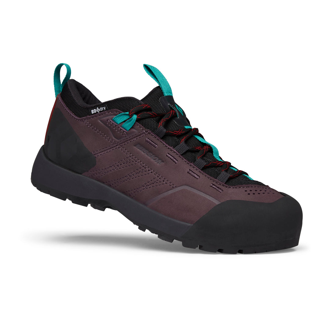 A single, dark purple hiking shoe with teal and red accents is shown from a side angle against a white background. The shoe features a rugged sole, reinforced toe, and laces. Text overlays the image, stating "Push your limits on every adventure. Black Diamond gear built to perform where it matters most." The shoe appears to be designed for outdoor activities, with a focus on durability and performance.