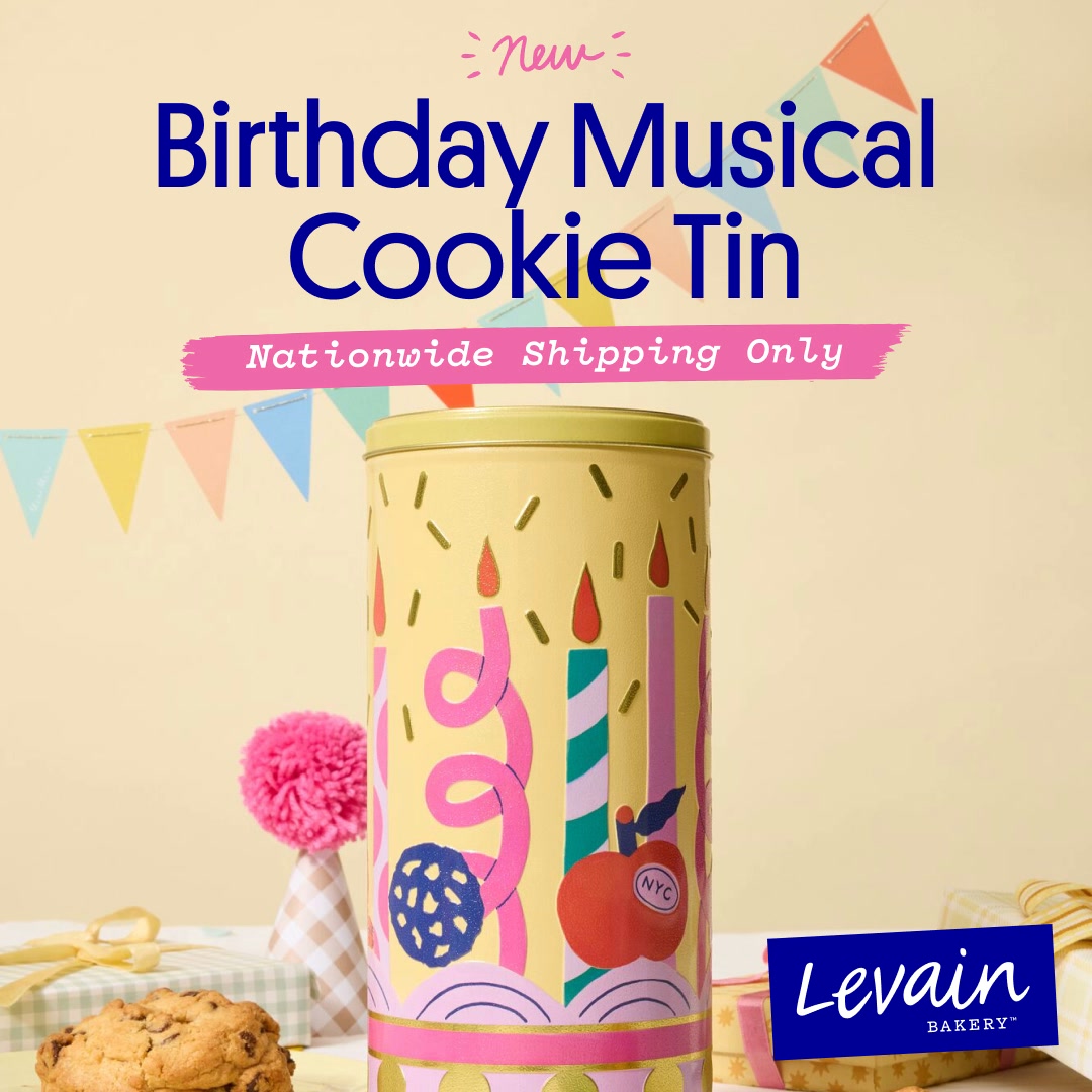 A bright, festive image features a tall, yellow cookie tin decorated with birthday candles and confetti. The text "New Birthday Musical Cookie Tin" is prominently displayed at the top. Below the tin, a pink banner reads "Nationwide Shipping Only." In the foreground, a single chocolate chip cookie rests on a table next to a gift-wrapped box. The Levain Bakery logo is visible in the bottom right corner.