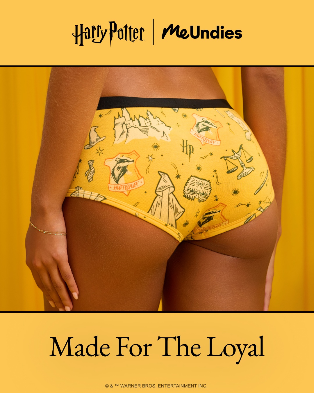 The image shows the back of a person wearing yellow underwear with a Harry Potter Hufflepuff print. The print features various symbols from the Harry Potter universe, including the Hogwarts castle, a badger, and a wizard's hat. The text "Made For The Loyal" is displayed prominently at the bottom of the image in a large, bold font. The overall aesthetic is playful and nostalgic, appealing to fans of the Harry Potter franchise.