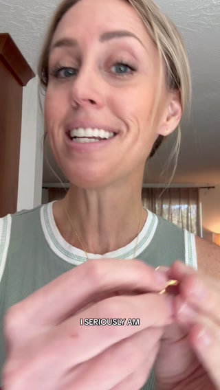 A woman with blonde hair pulled back is shown from the chest up, looking directly at the camera with a slight smile. She is wearing a green and white striped tank top and a delicate gold necklace. Her hands are in the foreground, appearing to adjust a small, shiny object. White text overlaid on the image reads "I SERIOUSLY AM". The ad copy states that there is a "Today only" offer for up to 25% off Perry hoops, with a call to shop while supplies last.
