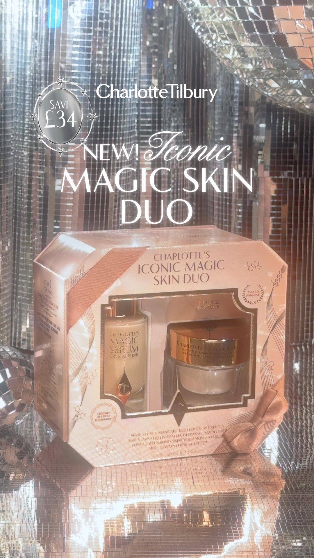 A product shot of the Charlotte Tilbury "Iconic Magic Skin Duo" gift set, featuring a serum and a cream. The background is a shimmering, reflective silver surface, resembling disco balls. Text overlays announce "SAVE £34" and "NEW! Iconic MAGIC SKIN DUO". The gift set itself is presented in a hexagonal box with a rose gold ribbon and bow. The copy mentions "perfect holiday gift" and includes gift emojis.