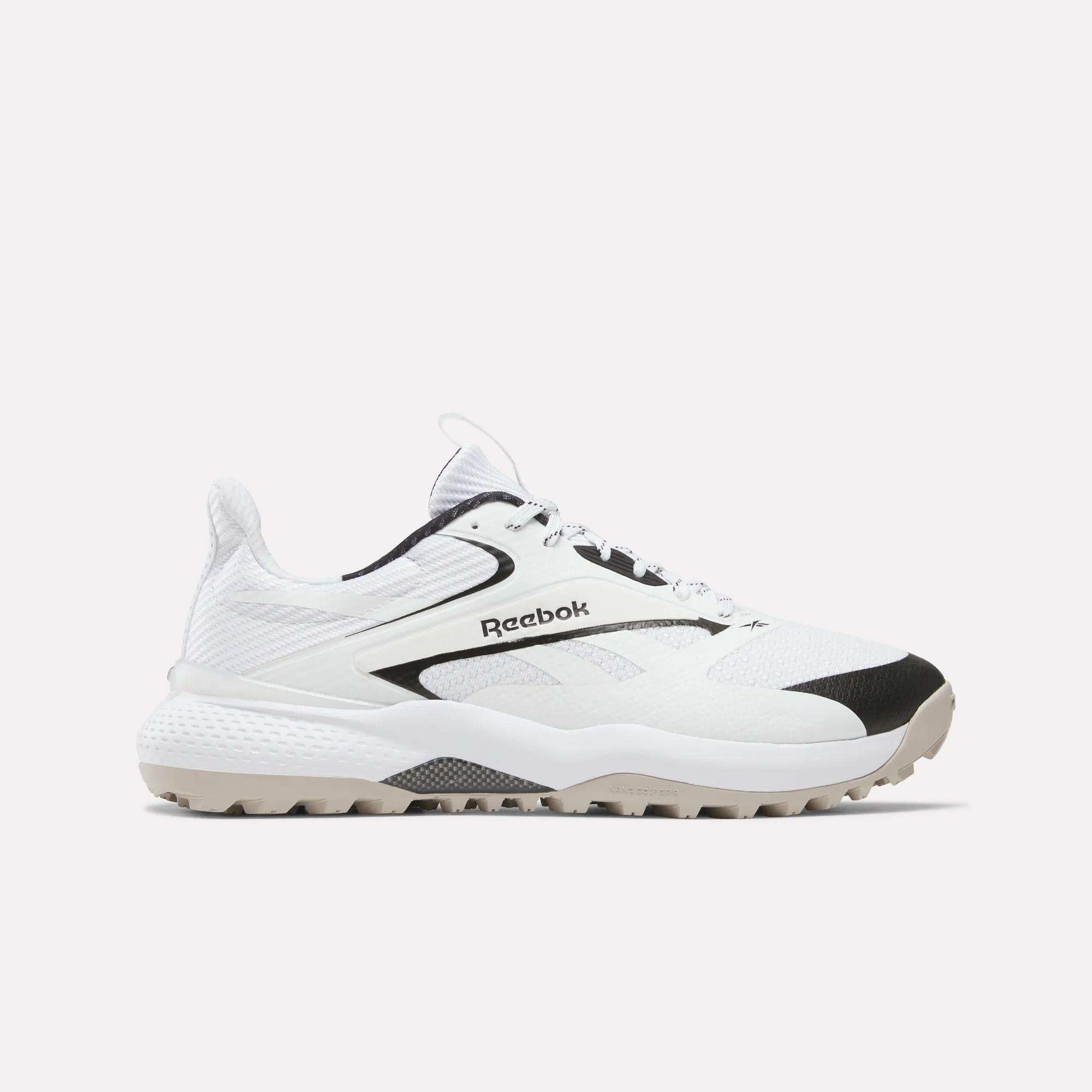 A white Reebok running shoe with black accents is shown in a side profile against a plain, light grey background. The shoe features a textured sole and a prominent Reebok logo on the side. There is no text or copy present on the creative itself, focusing solely on the product's visual presentation.