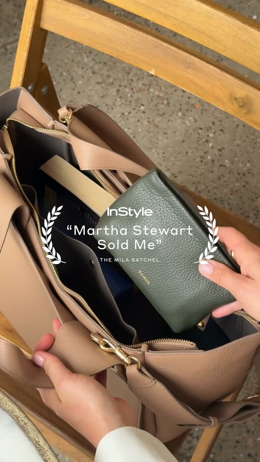A close-up shot shows a person's hands placing a green wallet into a tan leather tote bag. The bag is open, revealing its interior compartments. Overlaid on the image is text that reads "InStyle" and "Martha Stewart Sold Me" with laurel leaf graphics on either side of the quote. Below the quote, it says "THE MILA SATCHEL" and the brand name "CUYANA" is visible on the wallet.