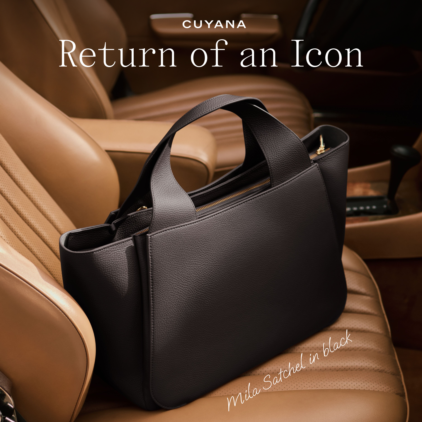 A black leather handbag, the Mila Satchel, is placed on the tan leather seat of a car. The Cuyana logo is visible at the top of the image, with the text "Return of an Icon" prominently displayed in a serif font. Below the handbag, in a script font, is the text "Mila Satchel in black." The overall aesthetic suggests luxury and timeless style, highlighting the return of a popular product.