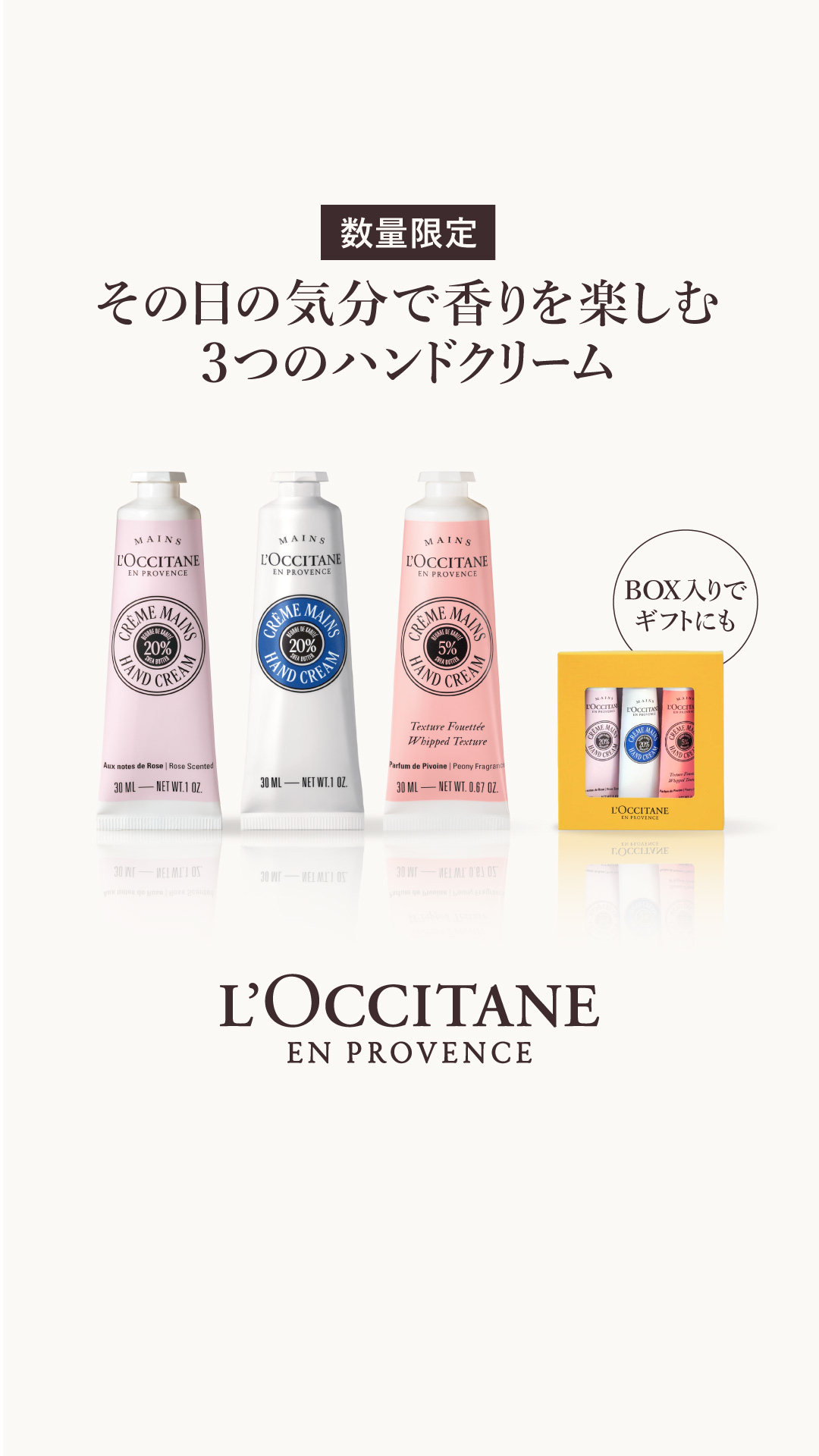 Three tubes of L'Occitane hand cream are displayed in the center of the frame. To the right, a small yellow box contains three miniature hand creams, with a circular graphic overlay that reads "BOX入りでギフトにも" (Also great as a gift in a box). The main text on the screen, in Japanese, reads "数量限定" (Limited quantity) at the top, followed by "その日の気分で香りを 楽しむ 3つのハンドクリーム" (Enjoy fragrances according to your mood, 3 hand creams). The L'Occitane en Provence logo is visible at the bottom.