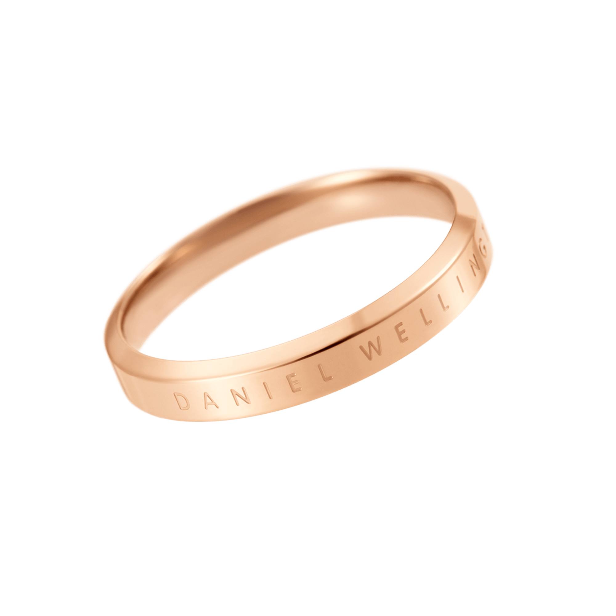A rose gold ring with the brand name "DANIEL WELLINGTON" engraved on its surface is shown against a white background. The ring is angled to display the engraving. The text "Wykonane perfekcyjnie." is overlaid on the image, translating to "Made perfectly."