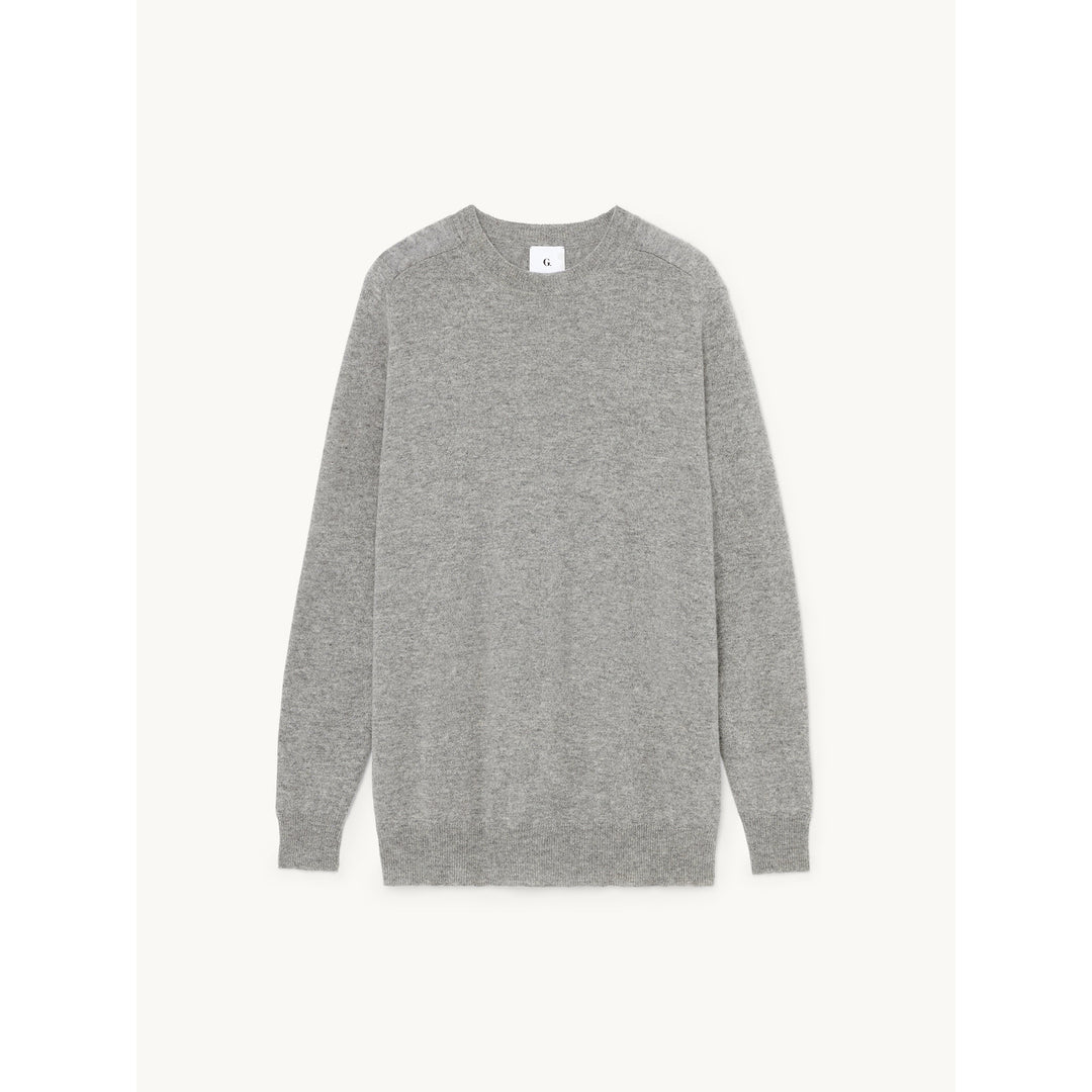 A plain grey crewneck sweater is shown flat against a white background. The sweater is centered in the frame. A small 'G.' logo is visible on the left side of the collar. Text overlaying the image reads "something catch your eye? we think these styles would look great on you."