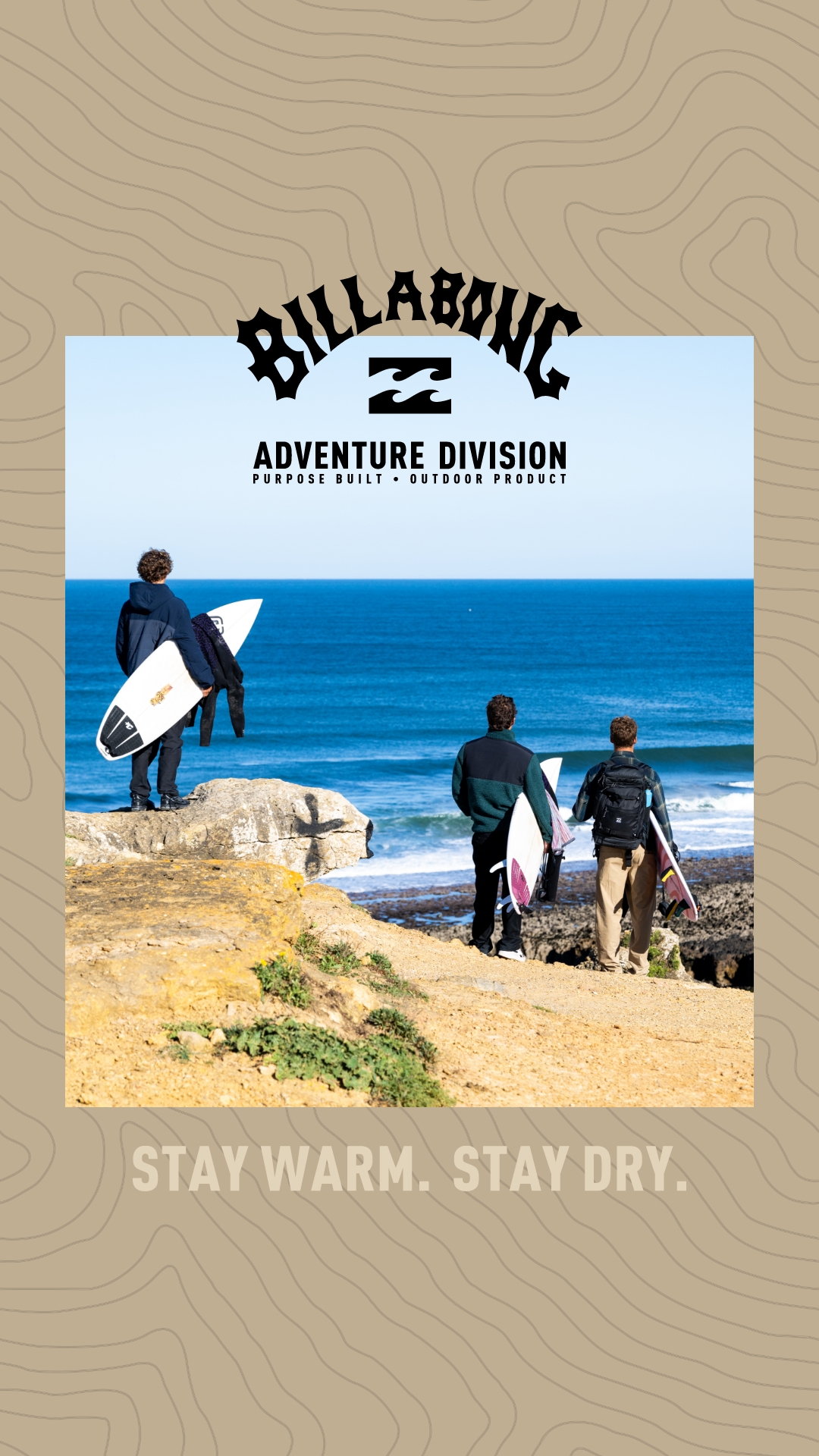 Three men stand on a rocky coastline, looking out at the ocean. Two of them hold surfboards. The Billabong logo and "ADVENTURE DIVISION" text are at the top of the image. The text "STAY WARM. STAY DRY." is overlaid at the bottom of the image.