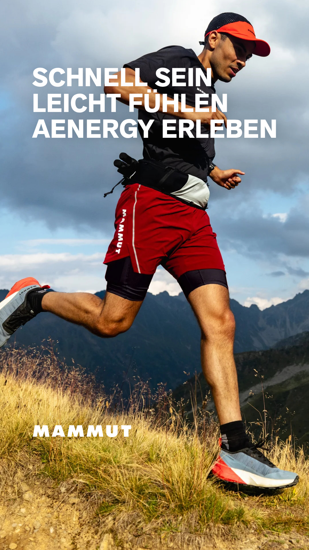 A man is running on a mountain trail, wearing red shorts and a black t-shirt. White text overlays the image, reading "SCHNELL SEIN LEICHT FÜHLEN AENERGY ERLEBEN" which translates to "Be fast Feel light Experience Aenergy". The Mammut logo is visible at the bottom of the image.