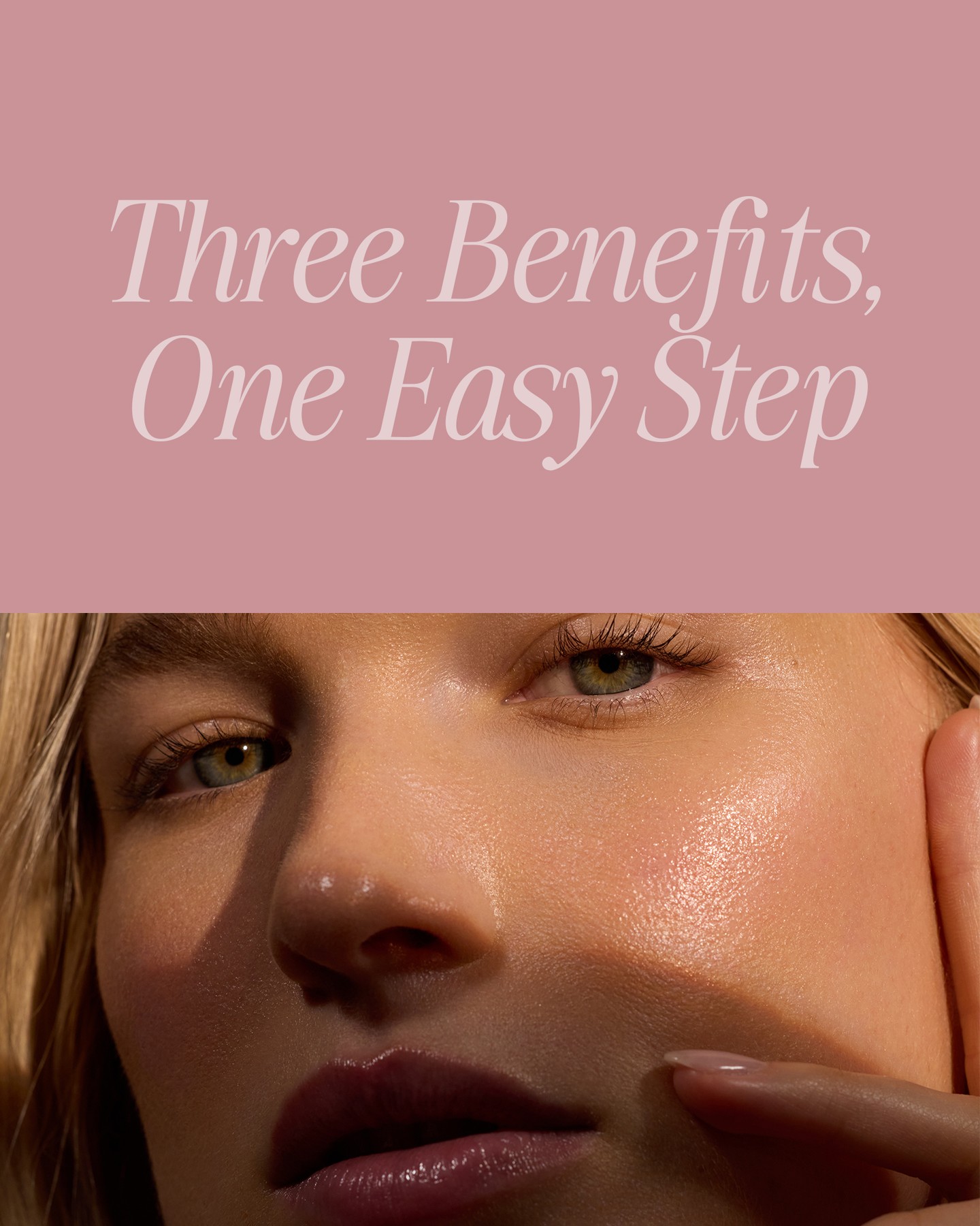 The top half of the image has a pale pink background with elegant white serif text that reads "Three Benefits, One Easy Step". The bottom half of the image is a close-up shot of a woman's face, focusing on her eye and cheek. Her skin appears dewy and radiant, with soft light highlighting her features. A finger is gently touching her cheek, adding a tactile element to the visual.