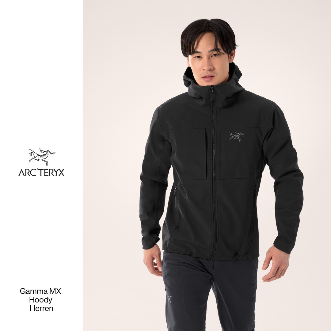 A studio shot of a man wearing a black Arc'teryx hooded jacket and dark pants. The Arc'teryx logo is visible on the left chest of the jacket. To the left of the man, the Arc'teryx logo and brand name are displayed, followed by the text "Gamma MX Hoody Herren". The headline "Bleib bei deinen Wintermissionen mit warmer, funktioneller Kleidung inspiriert." is overlaid on the image.