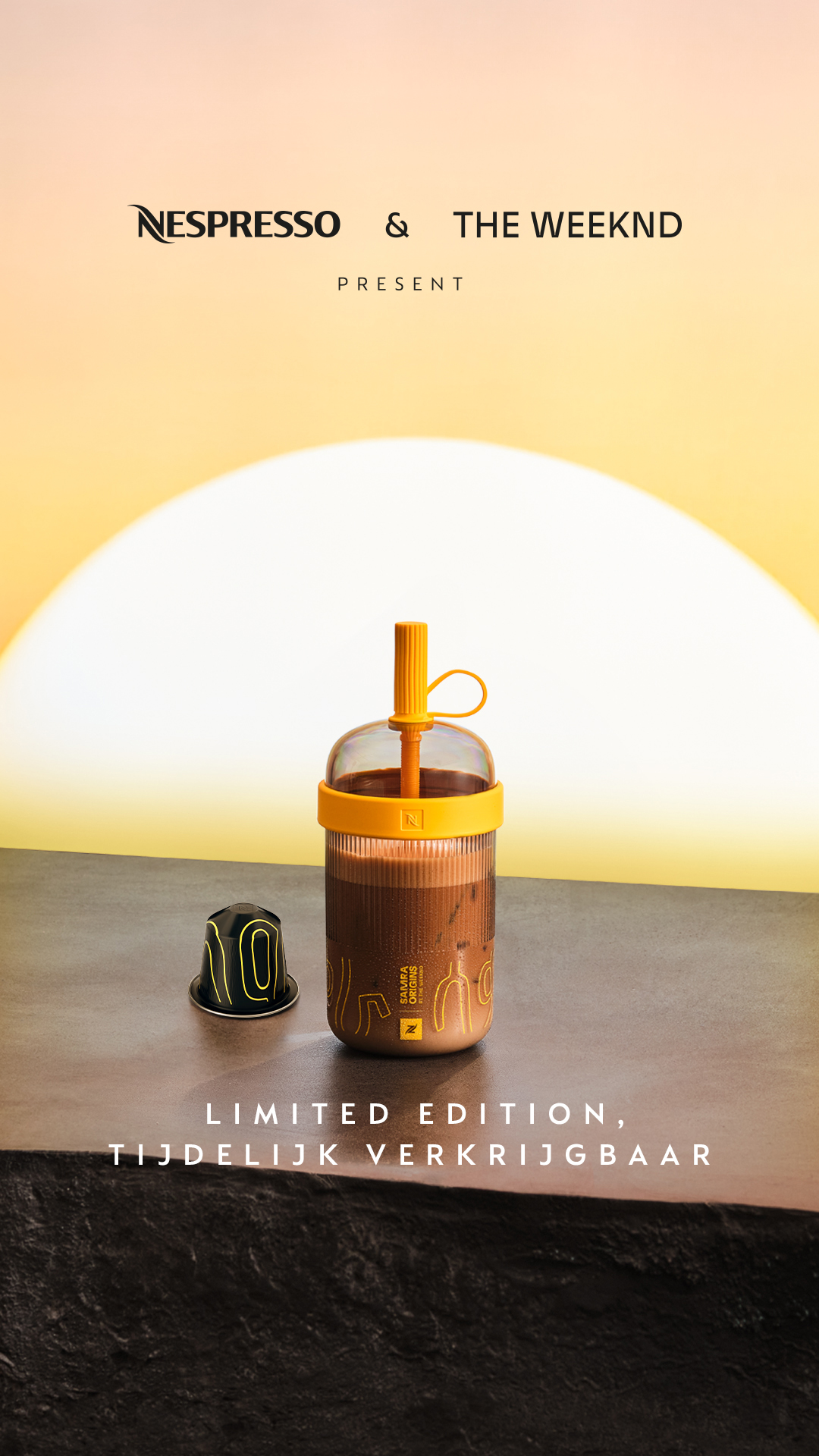 A Nespresso coffee capsule and a Nespresso branded tumbler filled with iced coffee are displayed on a textured surface against a soft yellow and orange gradient background. The tumbler has a yellow lid and straw, and the Nespresso logo is visible on the tumbler and the capsule. Text overlays read "LIMITED EDITION," and "TIJDELIJK VERKRIJGBAAR" (Dutch for "TEMPORARILY AVAILABLE"). The creative highlights a limited edition tumbler in a new color, implying its popularity and desirability.