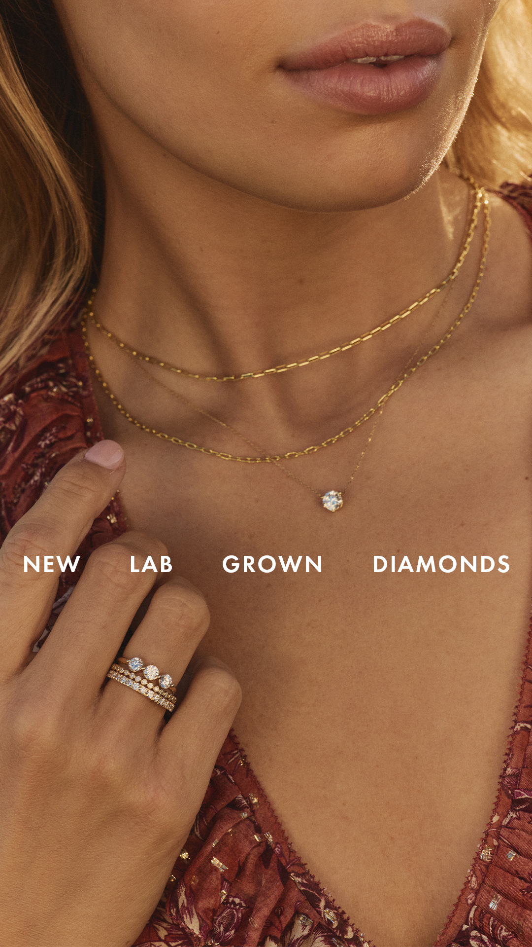 A close-up shot of a woman wearing multiple delicate gold necklaces and rings. The text "NEW LAB GROWN DIAMONDS" is overlaid on the image in white, sans-serif font. The focus is on the jewelry, highlighting the sparkle and design of the necklaces and rings, with the text emphasizing the origin of the diamonds.