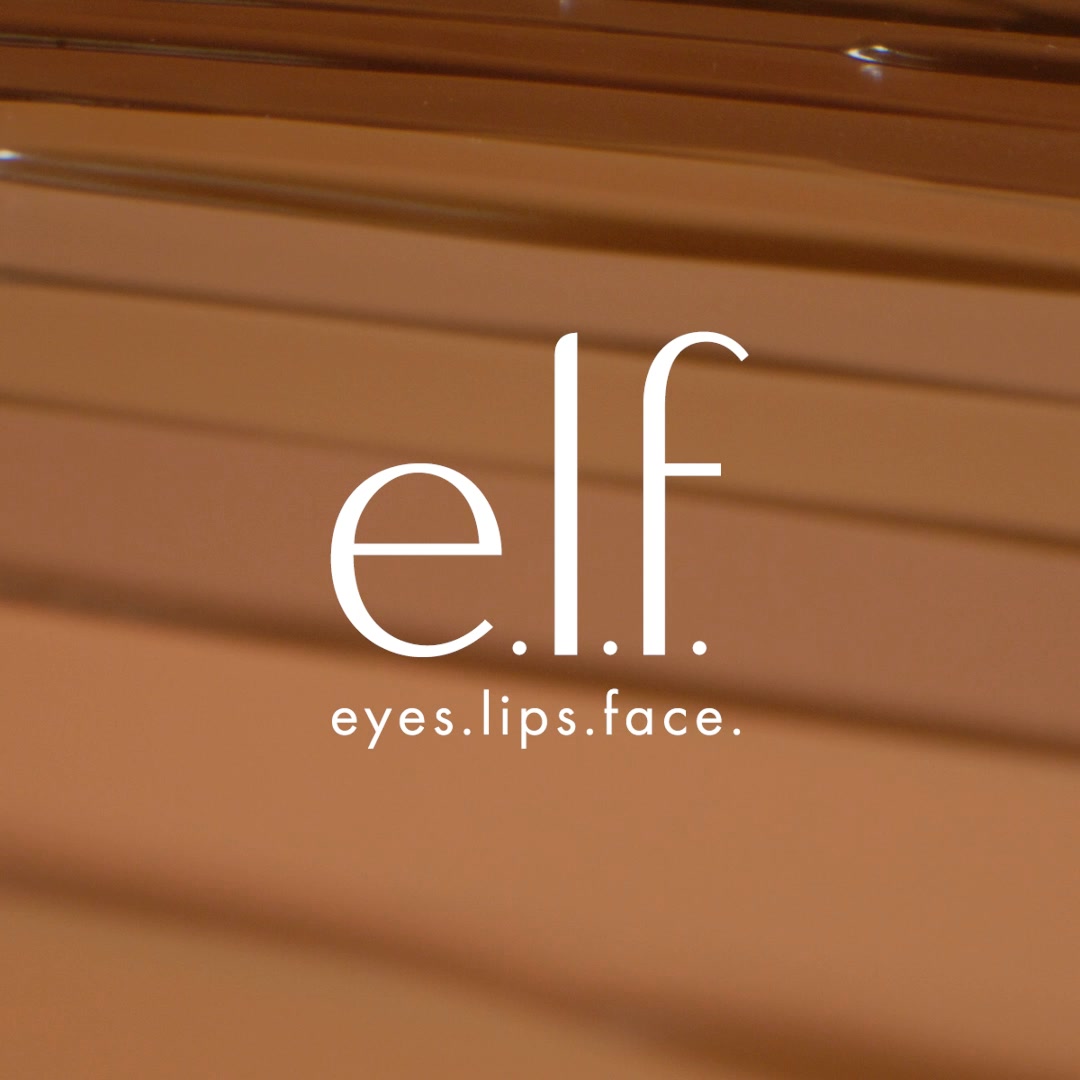 The creative features the E.l.f. Cosmetics logo in white, with the tagline "eyes.lips.face." centered below it. The background is a warm, gradient brown, possibly representing a foundation shade or texture. There is no discernible hook text or offer presented directly on the visual itself, relying on the brand's established identity.