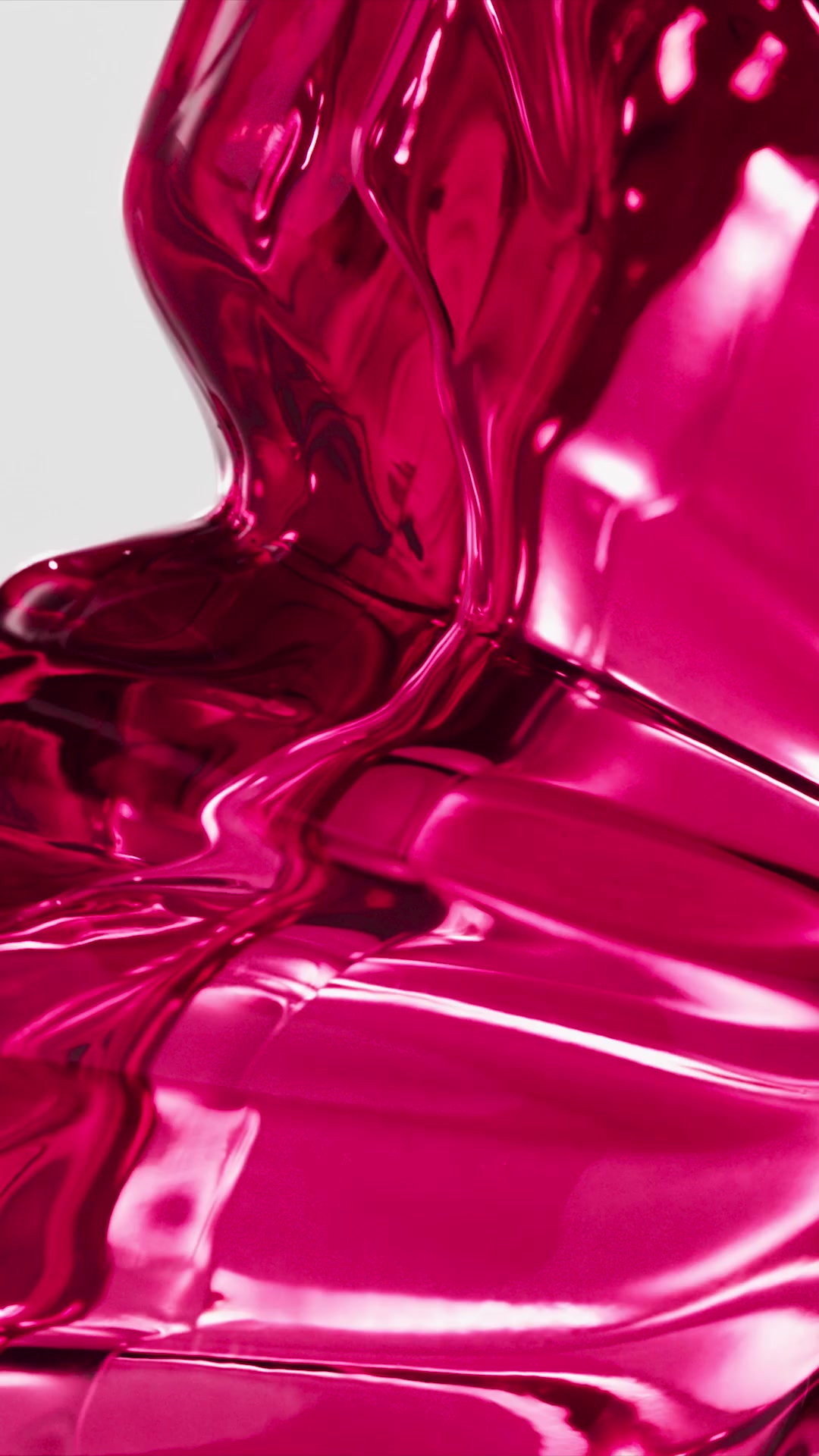 A close-up, abstract shot of a glossy, metallic pink liquid that appears to be flowing and swirling. The liquid has a highly reflective surface, creating highlights and shadows that give it a dynamic, almost sculptural quality. Text overlays describe the scent notes of the fragrance, posing a question about its exotic combination of ingredients and calling it "BOMBA!"