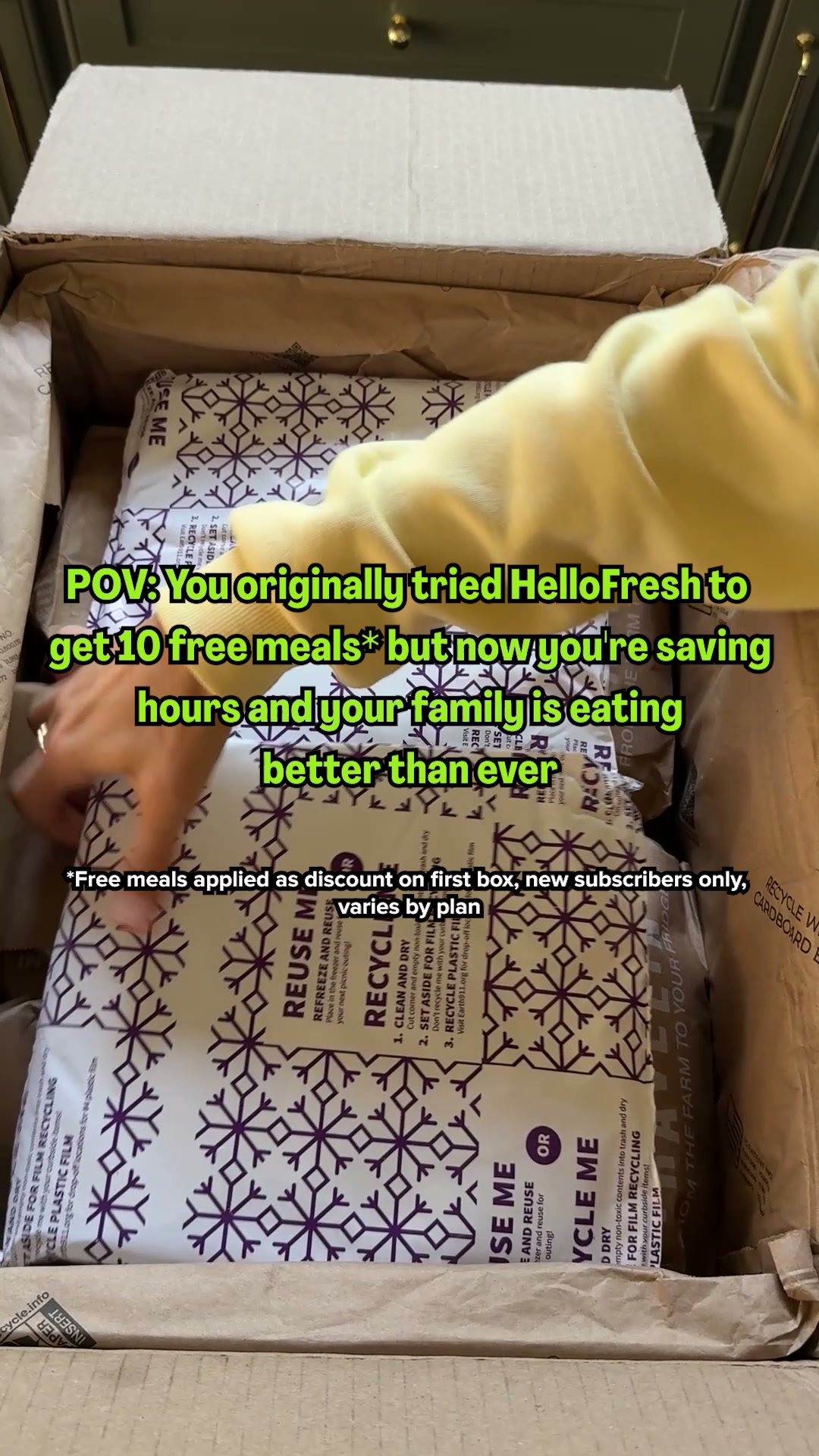The video shows a person's hands opening a HelloFresh box filled with pre-packaged meals. Text overlays the image, stating "POV: You originally tried HelloFresh to get 10 free meals* but now you're saving hours and your family is eating better than ever". Below this, smaller text clarifies the offer details. The creative highlights the convenience and improved family dining experience after trying the service.