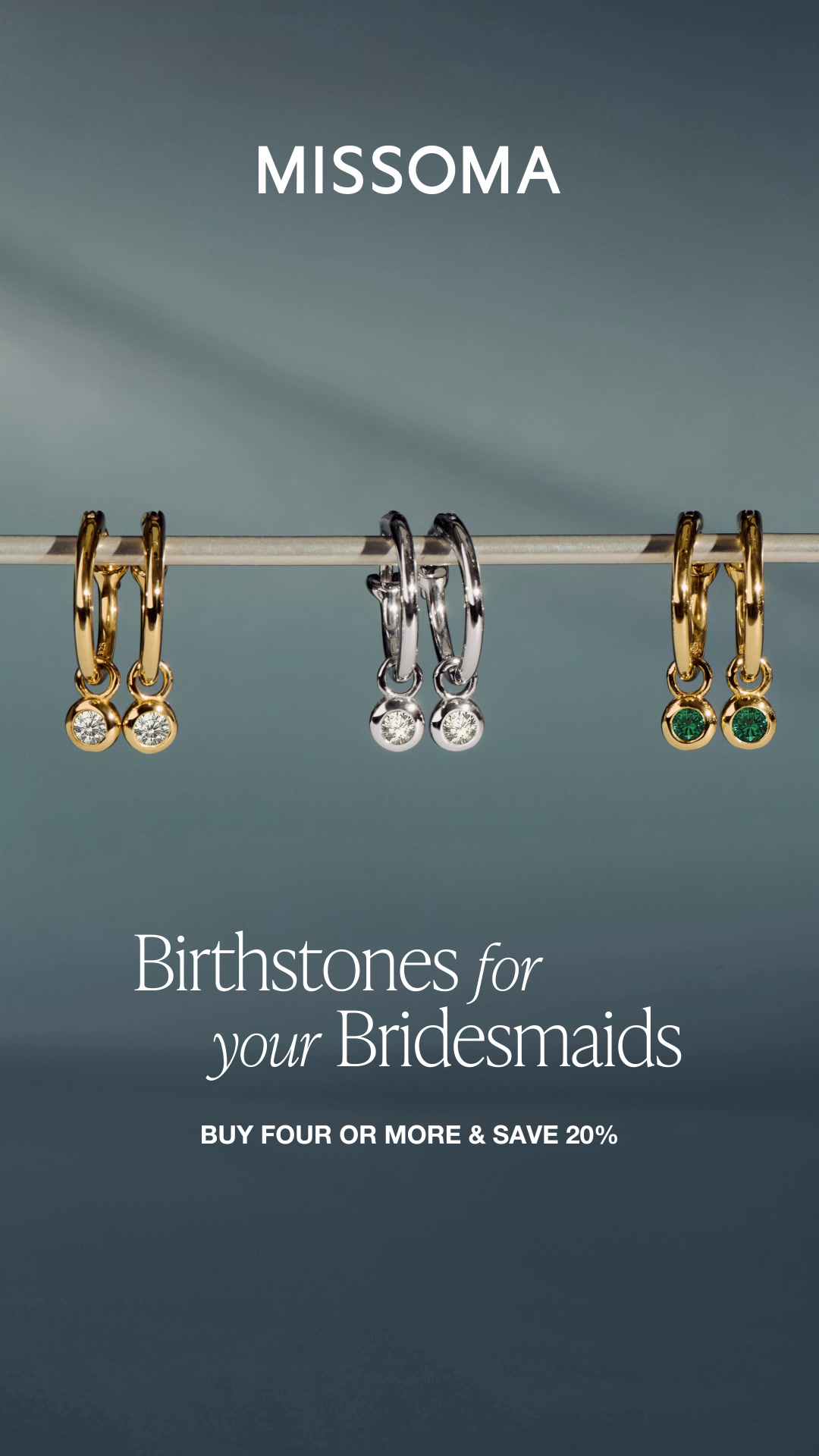 The ad displays three pairs of earrings hanging from a rod against a dark teal background. The Missoma logo is at the top. The text "Birthstones for your Bridesmaids" is overlaid on the image, followed by "BUY FOUR OR MORE & SAVE 20%". The earrings feature gold and silver settings with diamonds and green gemstones.