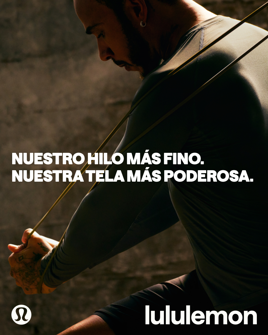 A man is shown from the chest up, performing a resistance exercise with a band. He is wearing athletic apparel. White text is overlaid on the image, stating "NUESTRO HILO MÁS FINO. NUESTRA TELA MÁS PODEROSA." The Lululemon logo is visible in the bottom left corner, and the brand name "lululemon" is in the bottom right corner.