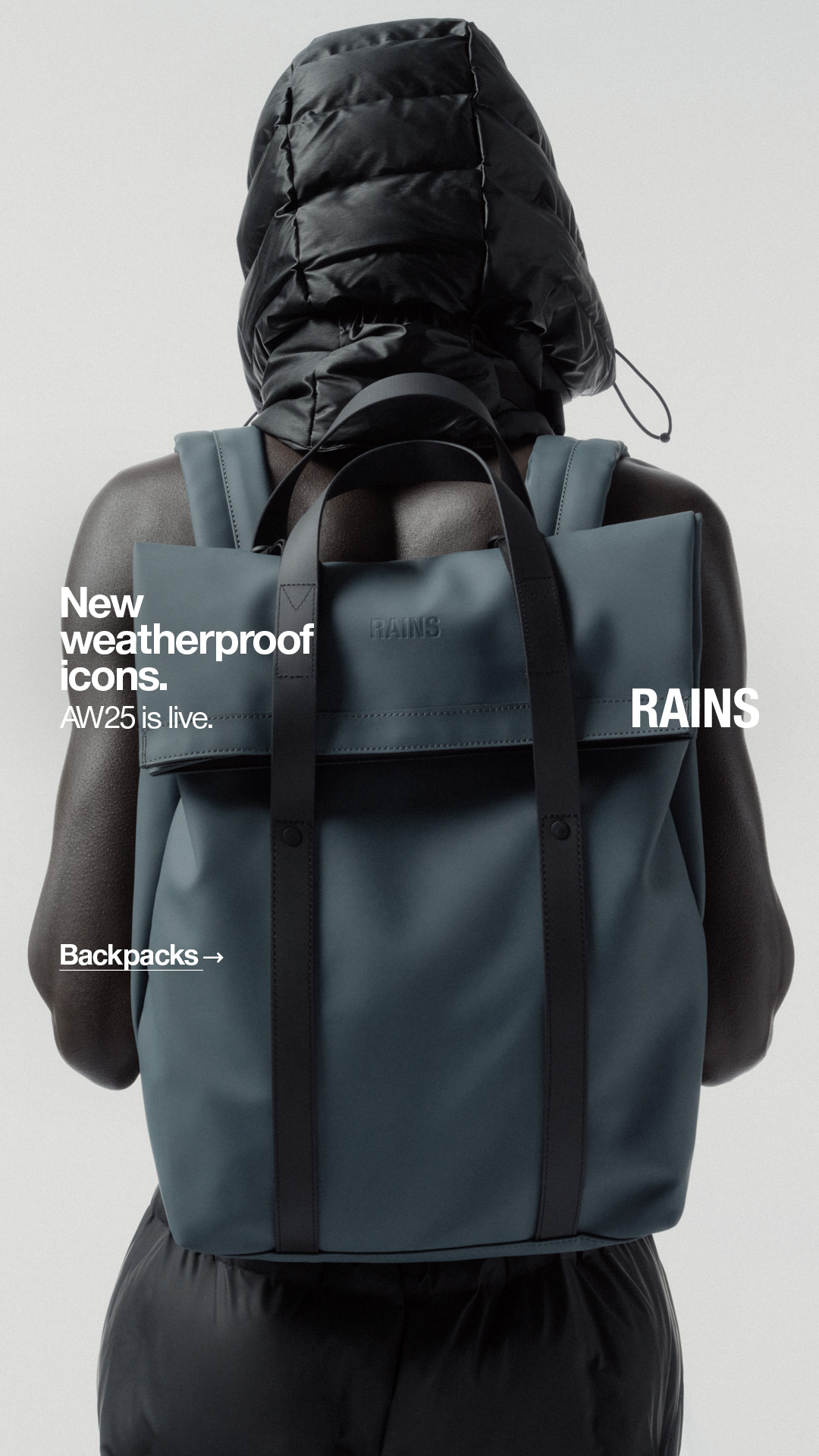 A person seen from behind wears a black puffer jacket with a hood and a teal backpack. White text on the left side of the image reads "New weatherproof icons. AW25 is live." Below this, smaller white text says "Backpacks →". The Rains logo is visible on the backpack and on the right side of the image.