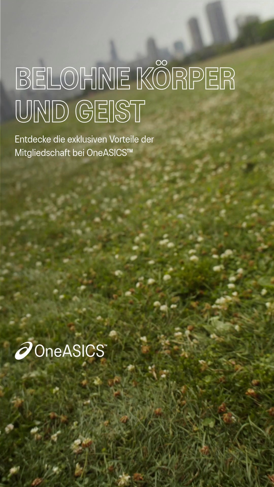 The creative features a grassy field with scattered white flowers in the foreground, and a blurred cityscape in the background. Large, white, sans-serif text overlays the image, reading "BELOHNE KÖRPER UND GEIST" (Reward Body and Mind). Below this, smaller text states "Entdecke die exklusiven Vorteile der Mitgliedschaft bei OneASICS™" (Discover the exclusive benefits of OneASICS™ membership). The OneASICS™ logo is visible in the bottom left corner.