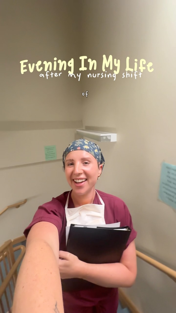 A woman in scrubs and a surgical cap smiles at the camera, holding a black folder. Text overlays the top of the image, reading "Evening In My Life after My nursing shift of". The woman appears to be in a hospital hallway, possibly on the stairs, as a railing is visible to her left. The overall impression is a "day in the life" style video from a nurse after her shift.