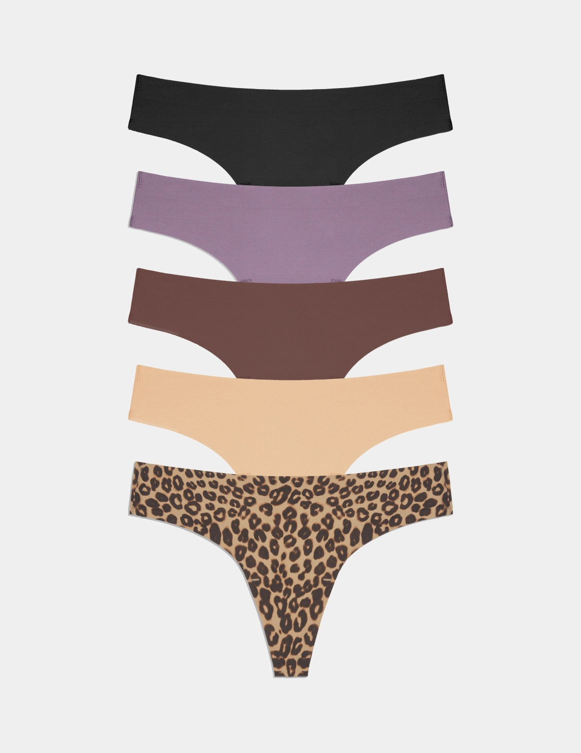 A flat lay of five pairs of seamless thong underwear, stacked vertically against a light grey background. From top to bottom, the colors are black, lavender, chocolate brown, nude, and leopard print. The text "Time for a refresh. Upgrade your top drawer to Knix undies." is overlaid on the image in a simple, sans-serif font.