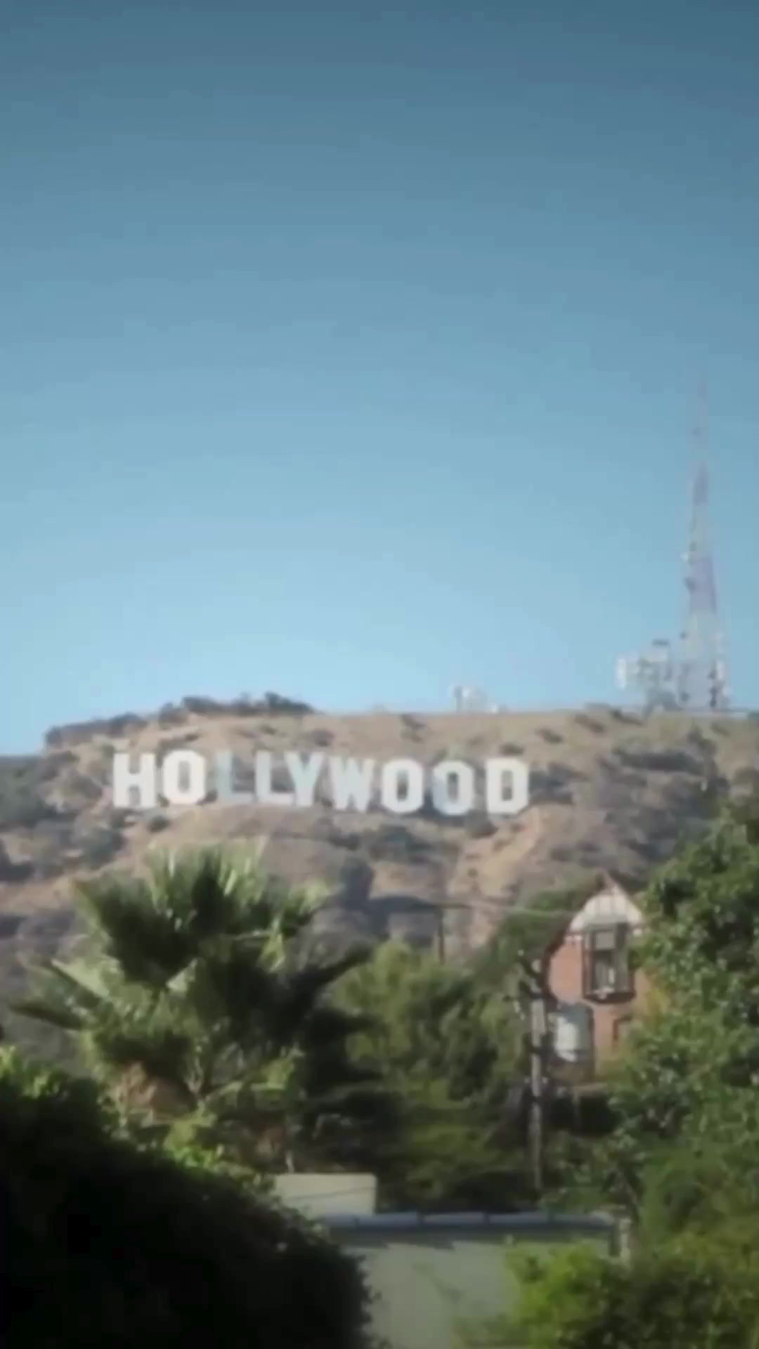 The image shows the iconic Hollywood sign on a hill under a clear blue sky. In the foreground, there are trees and a glimpse of a building. The text overlay, which is part of the ad copy, begins with a personal anecdote about struggling with health issues despite looking the part of a fitness trainer. It sets up a narrative of overcoming these challenges through a whole food diet.