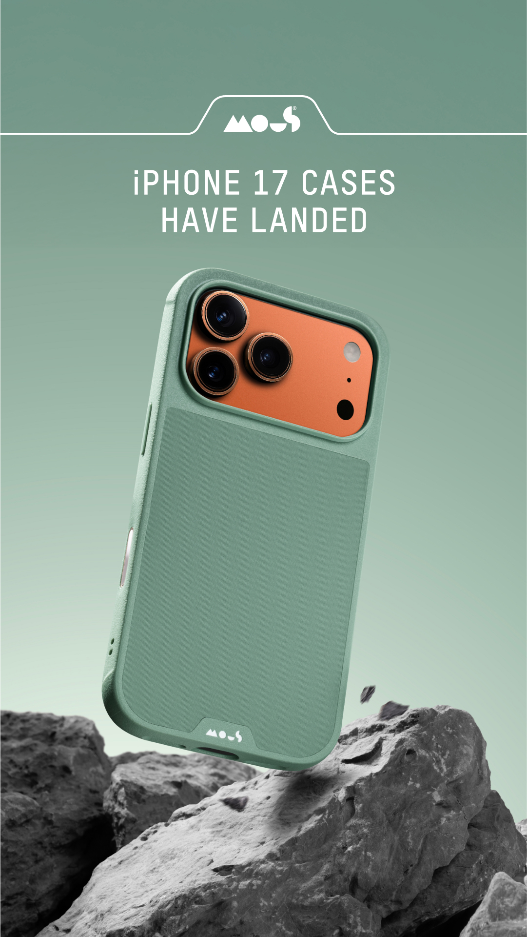A close-up shot of a green iPhone case is shown at an angle, with a grey, rocky surface in the foreground and a muted green background. White text overlaying the image reads "IPHONE 17 CASES HAVE LANDED" and displays the "Mous" logo. The creative highlights the arrival of new iPhone cases, emphasizing their protective qualities and sleek design.