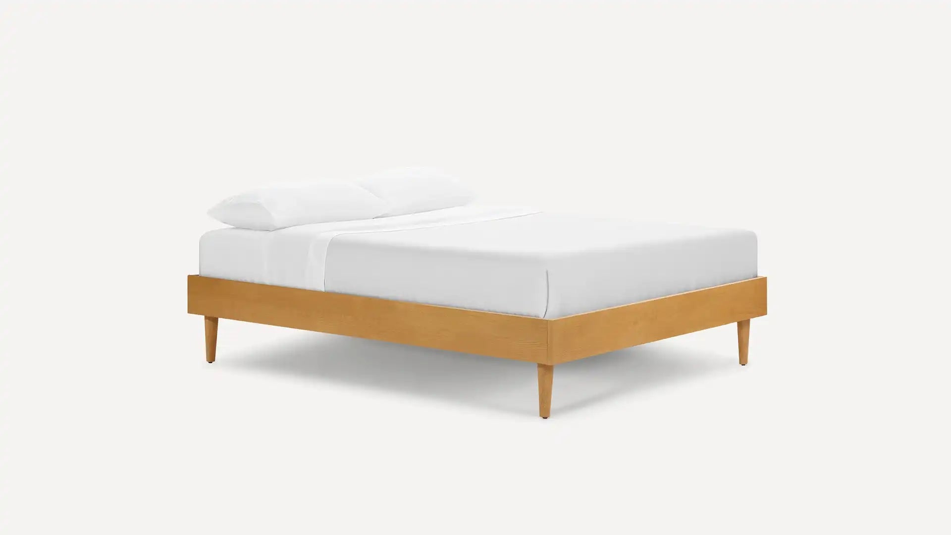 A clean studio shot of a Burrow bed frame with a mattress and white bedding. The bed frame is made of light-colored wood and has four tapered legs. White text overlays the image, stating "Your home isn't one-size-fits-all. Neither is your furniture." The ad promotes modular furniture pieces with a discount of up to 40%.