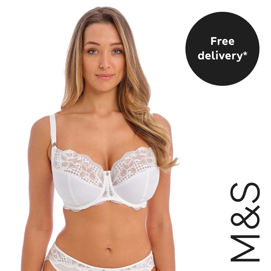 A woman wearing a white lace bra and matching underwear is shown from the chest down against a white background. A black circle graphic overlay in the top right corner contains the white text "Free delivery*". The M&S logo is displayed vertically in black text on the right side of the image.